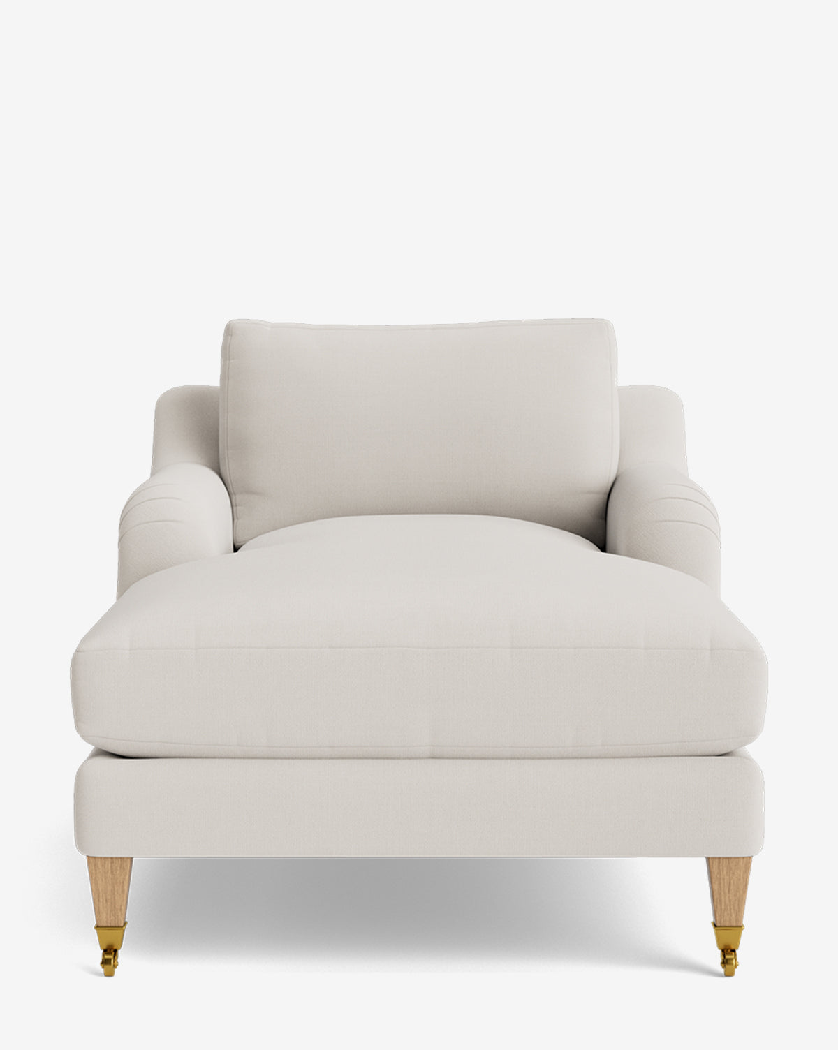The Lucille English Roll Arm Lounge Chair in light beige has plush down-wrapped cushions, rounded armrests, and wooden legs—two with brass casters—shown on a plain white background by McGee & Co.