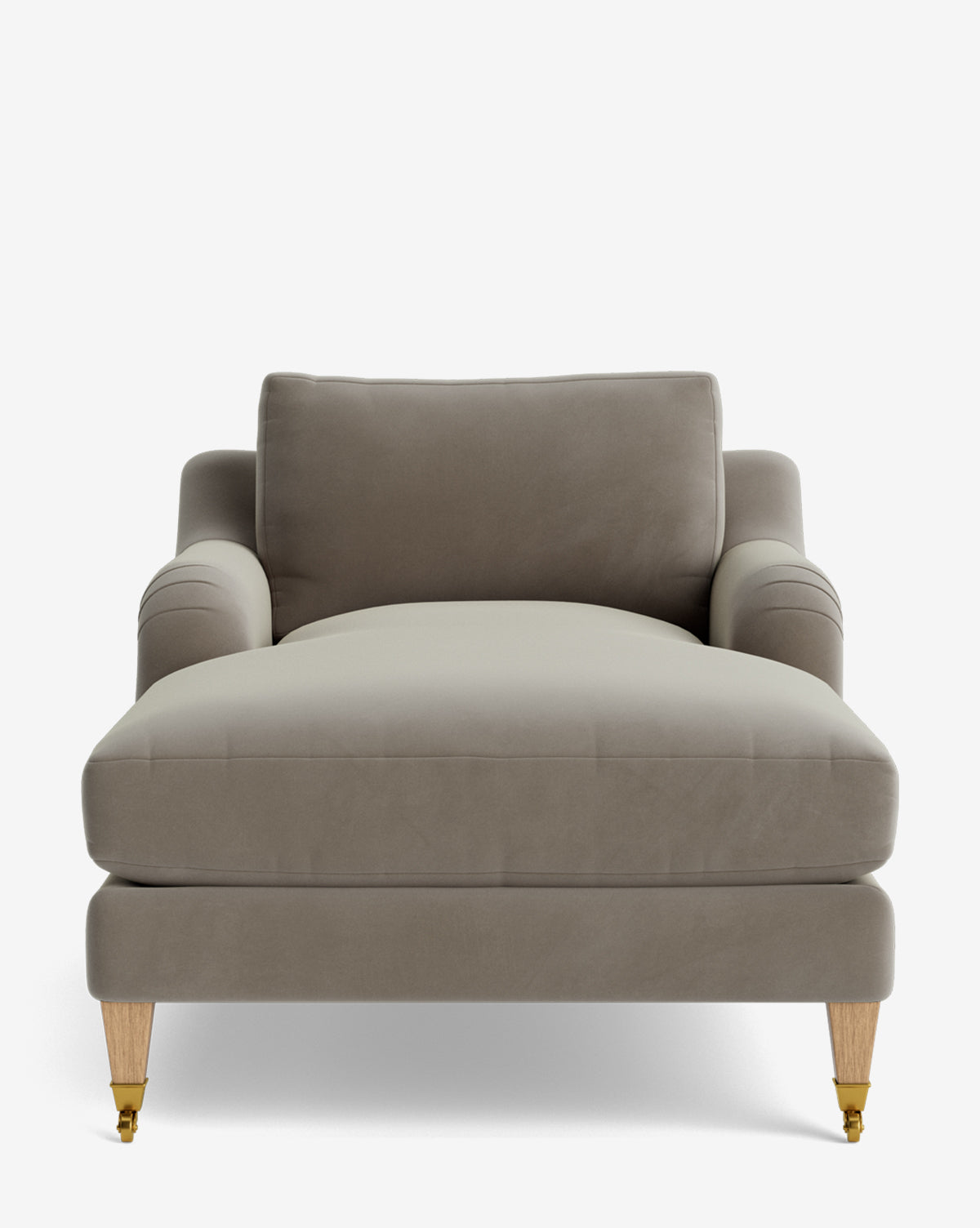 The Lucille English Roll Arm Lounge Chair features a modern taupe design with plush down-wrapped cushions, curved armrests in the English roll style, and light wooden legs—two accented with brass casters, by McGee & Co. Shown against a plain white background by McGee & Co.