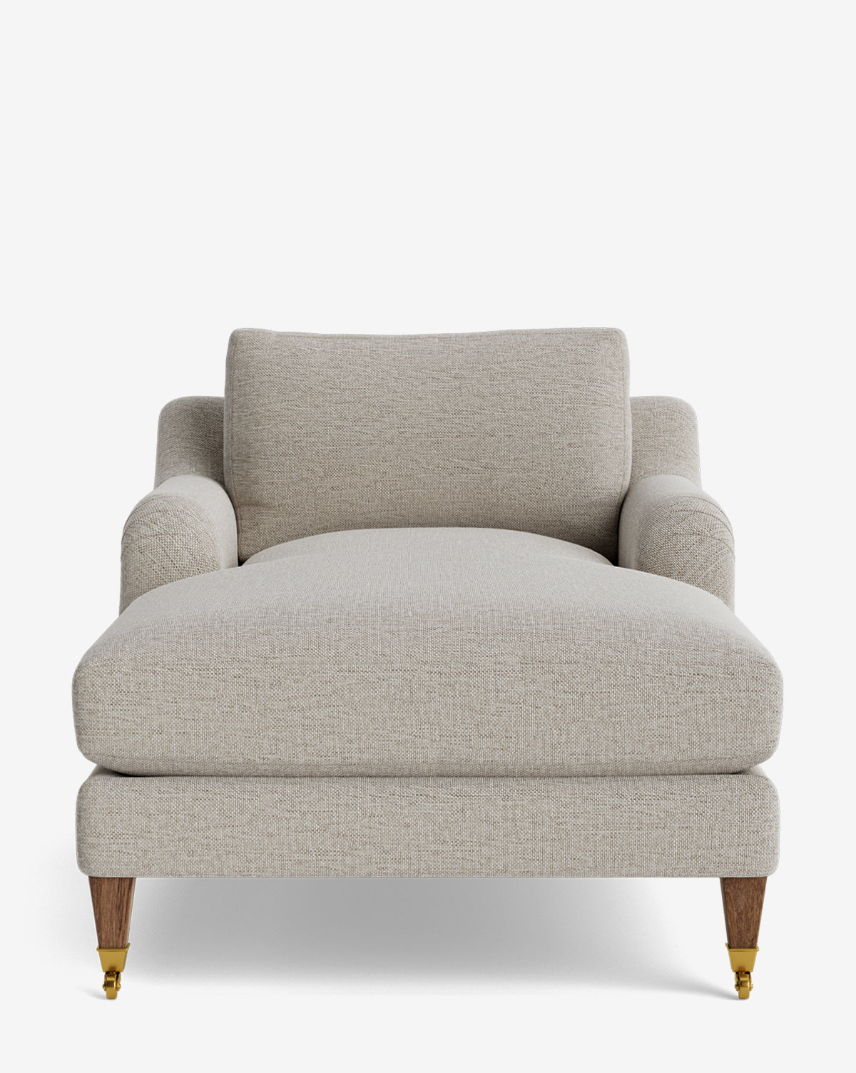 The Lucille English Roll Arm Chaise Lounge features a beige finish, wide seat, low backrest, rounded armrests, and wooden legs with brass castors on the front, by McGee & Co. It includes a plush down-wrapped cushion and is set against a plain white background.