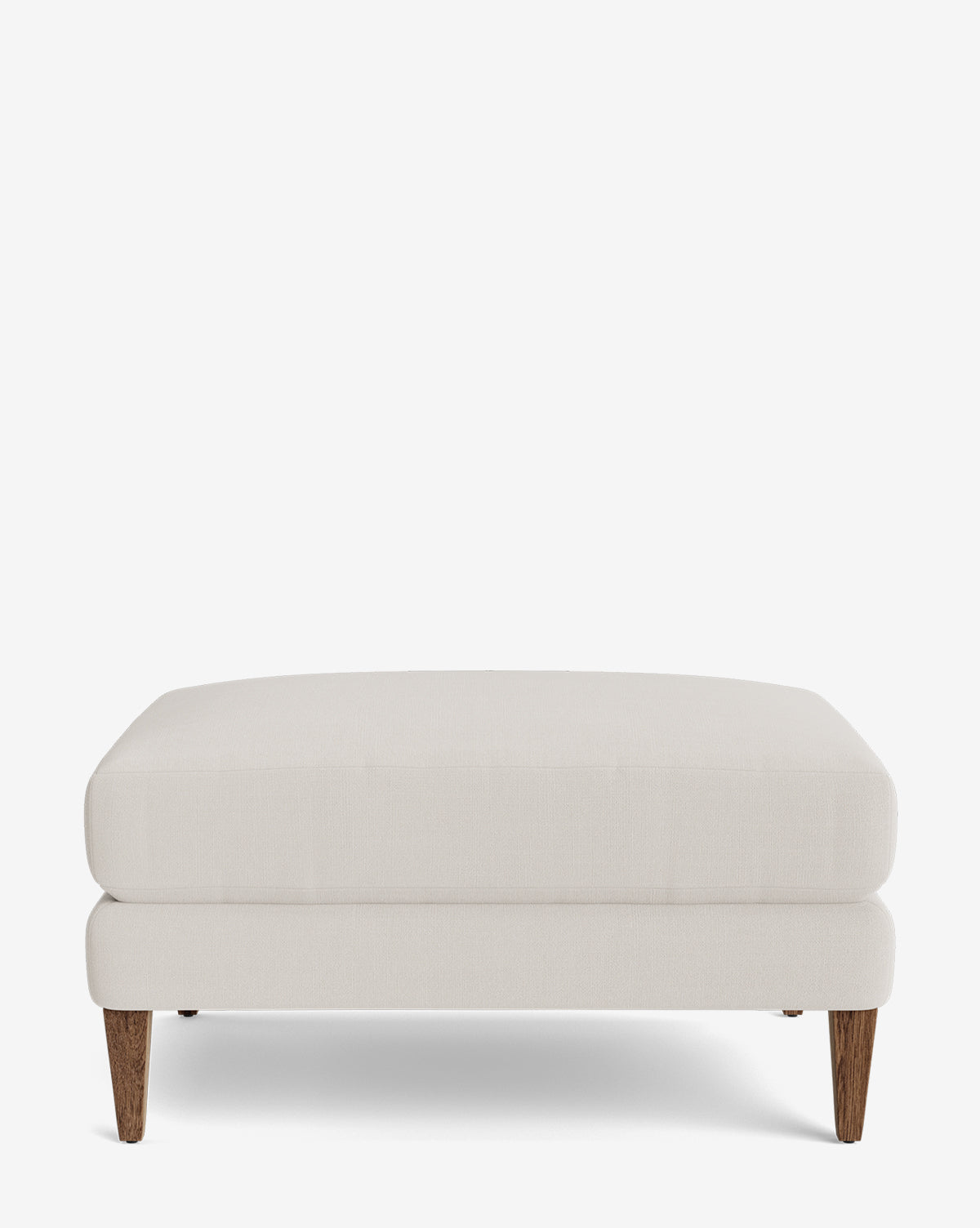 The Lucille Ottoman is a modern, beige, rectangular ottoman with wooden legs and a cushioned top. Its clean lines and simple design make it ideal for any room, by McGee & Co.