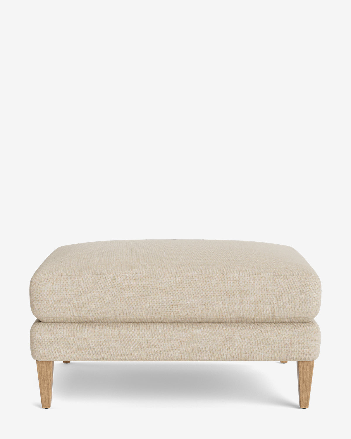 The Lucille Ottoman is a modern rectangular ottoman upholstered in beige fabric with wooden legs, displayed on a plain white background, by Vendixs