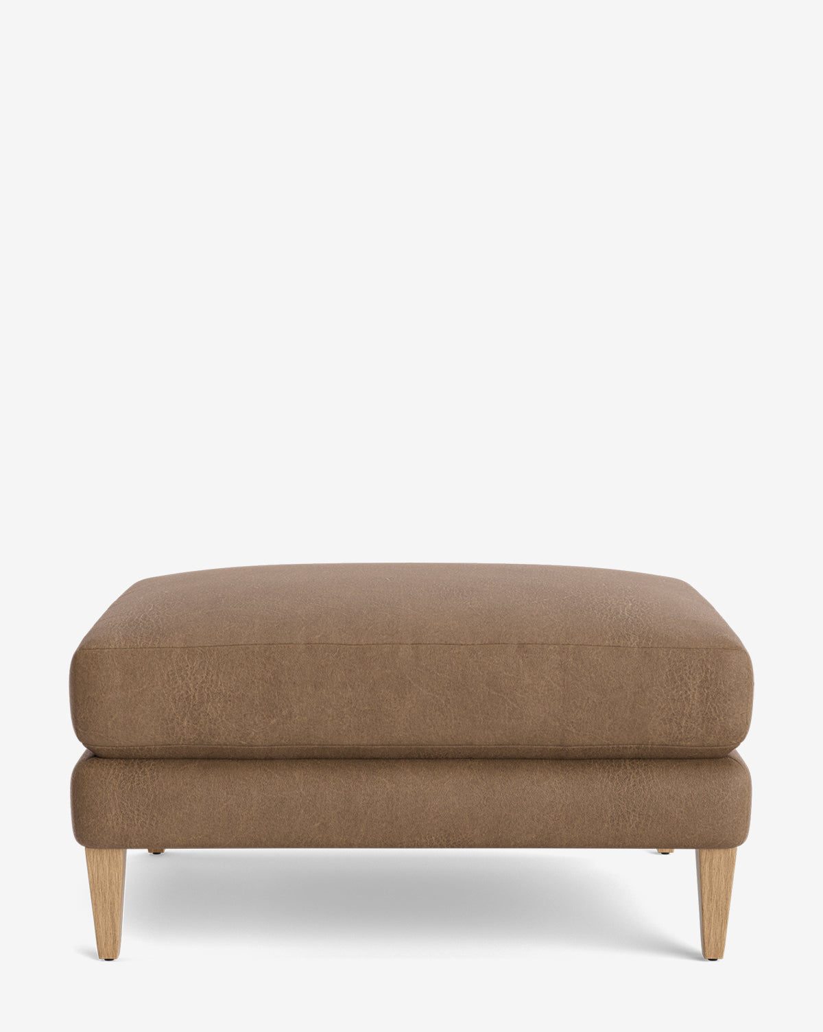 The Lucille Ottoman features a rectangular design with a cushioned top, wooden legs, and a modern brown finish, displayed on a plain white background by McGee & Co.