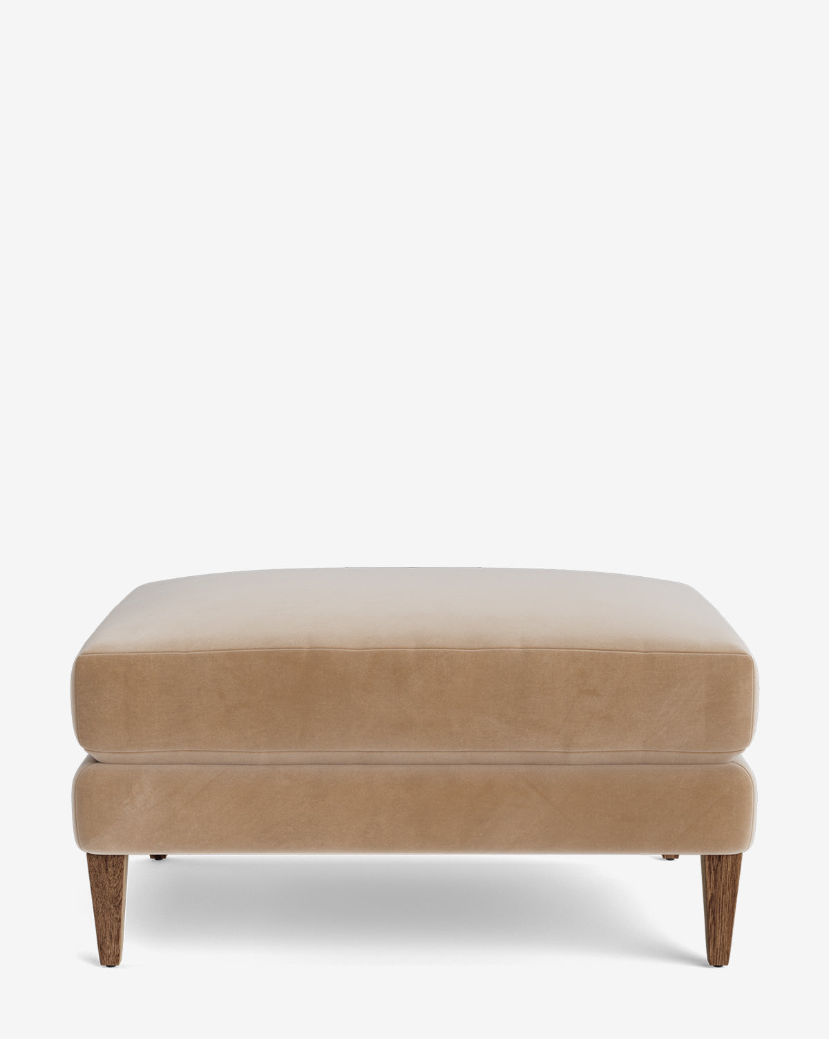 The Lucille Ottoman is a modern, rectangular beige ottoman with soft upholstery and four wooden legs, shown on a plain white background by McGee & Co.