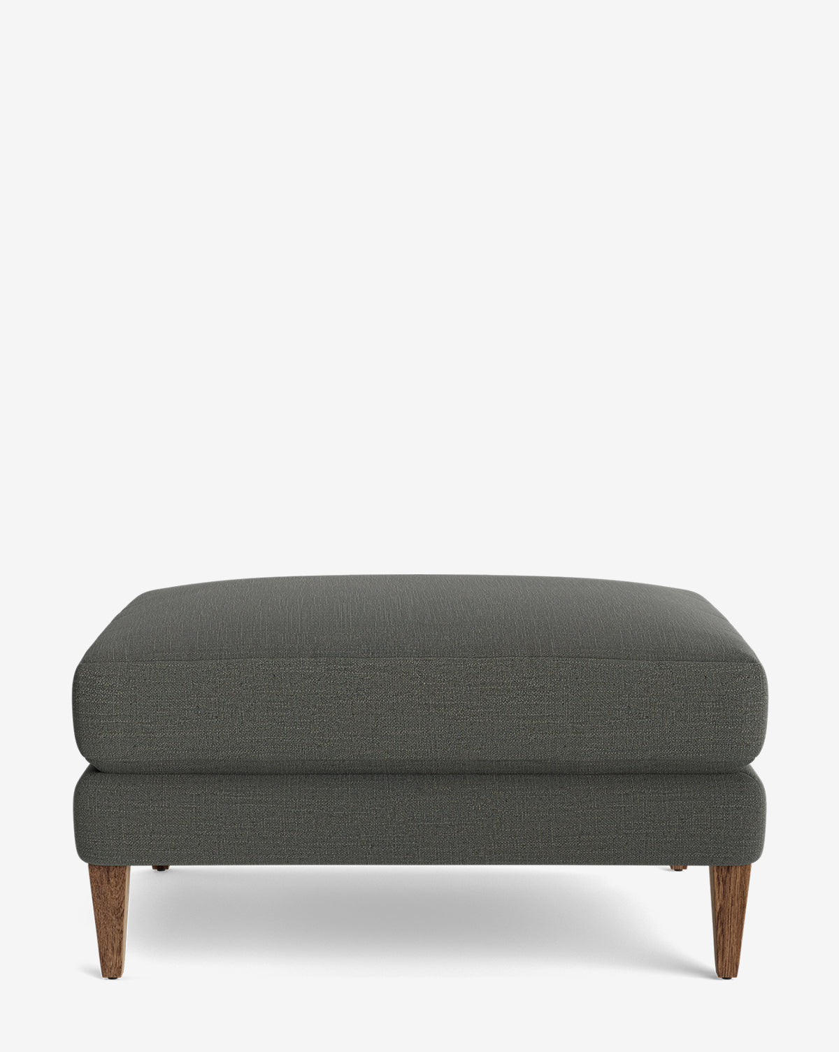The Lucille Ottoman is a modern rectangular piece with dark gray upholstery and four angled wooden legs, displayed on a white background, by Vendixs