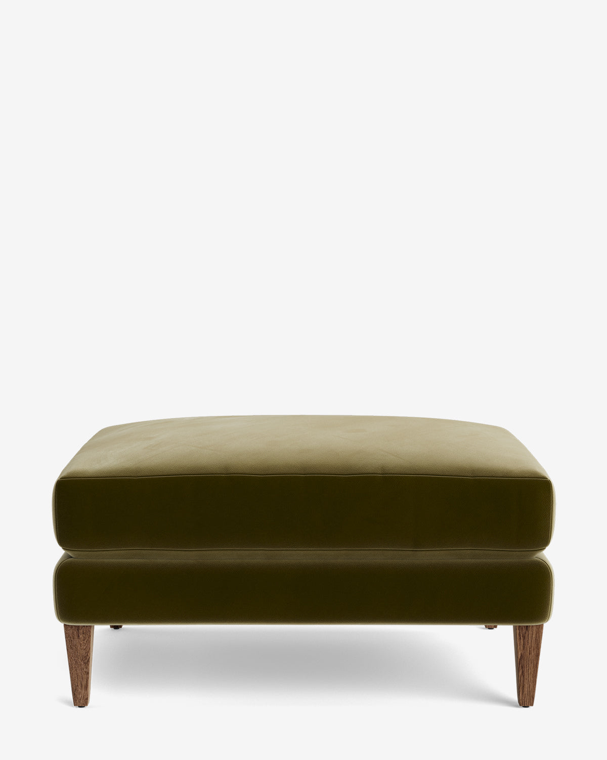 The Lucille Ottoman is a modern, square olive green velvet ottoman with short, angled wooden legs. Its versatile design allows for customization to complement your style and living space. Shown on a plain white background by Vendixs