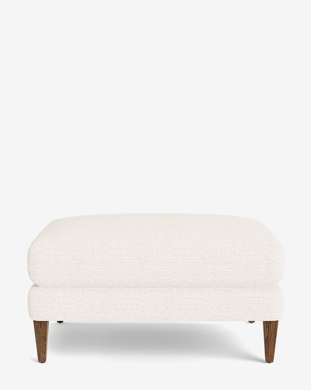 The Lucille Ottoman is a modern, rectangular ottoman with white upholstery and wooden legs, displayed against a plain white background, by McGee & Co. Its design is simple and contemporary.
