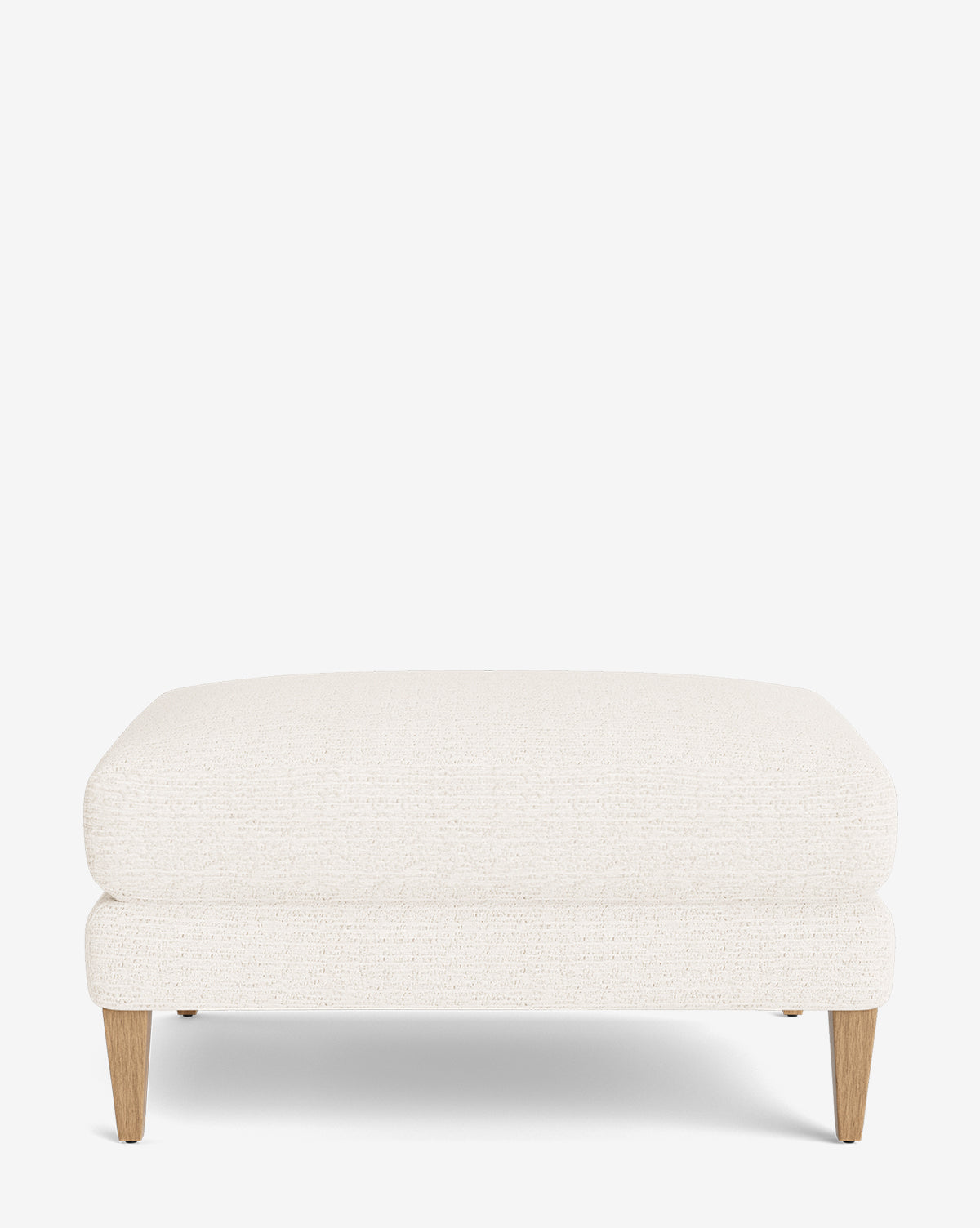 The Lucille Ottoman is a rectangular, customizable ottoman with short wooden legs and light beige upholstery, making it a perfect modern accent for any space, by McGee & Co.