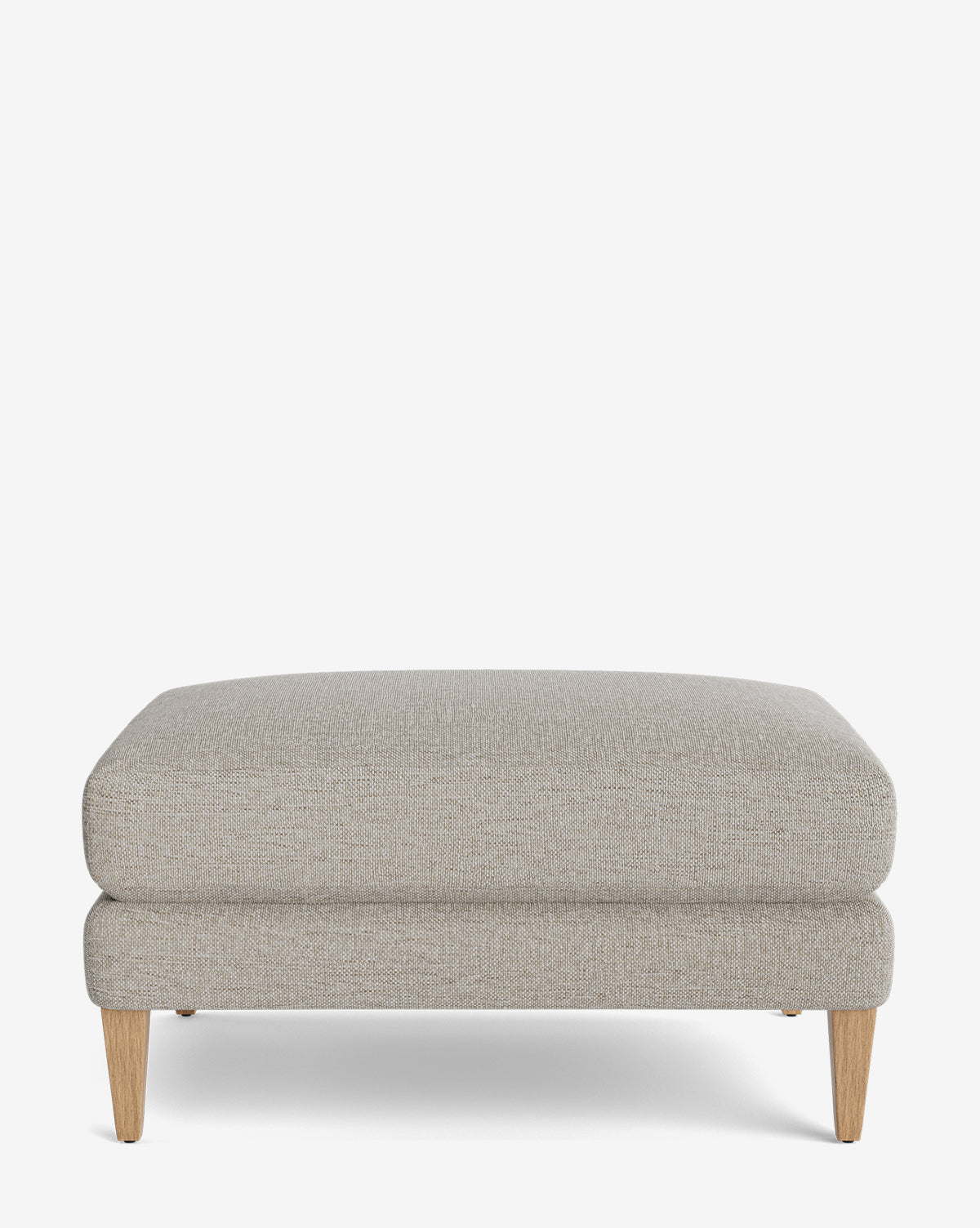 The Lucille Ottoman is a modern rectangular piece in light gray upholstery with a cushioned top and four light wooden legs, displayed on a plain white background, by Vendixs