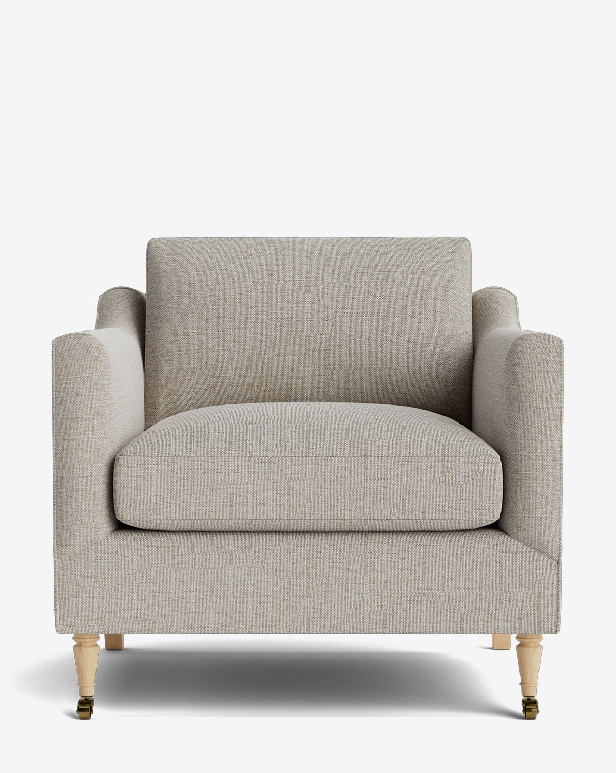 The Haverford Upholstered Lounge Chair features light beige fabric, a wide cushioned seat and back, straight armrests, and four light wooden legs with brass casters on the front two legs, by Vendixs