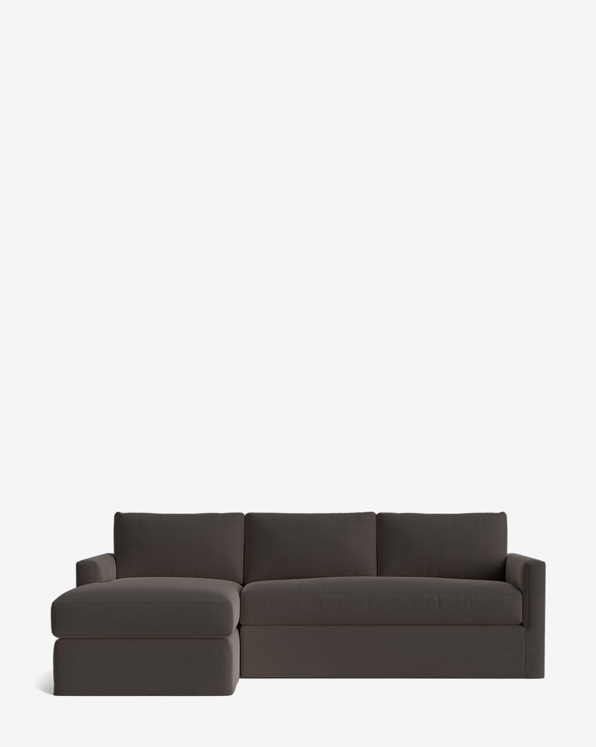 The Community Macy Slipcover Chaise Sectional 101 in modern dark gray features a left-side chaise lounge, three back cushions, and low armrests, shown on a plain white background for a sleek appearance. Vendixs