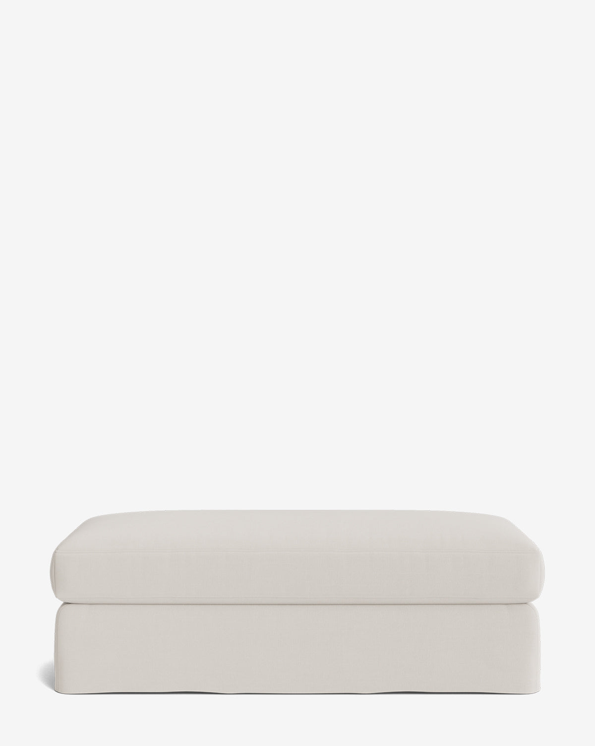 The Macy Slipcover Ottoman is a rectangular, light beige piece with a smooth, minimalist design—ideal for customizable living room setups—displayed on a plain white background by McGee & Co.