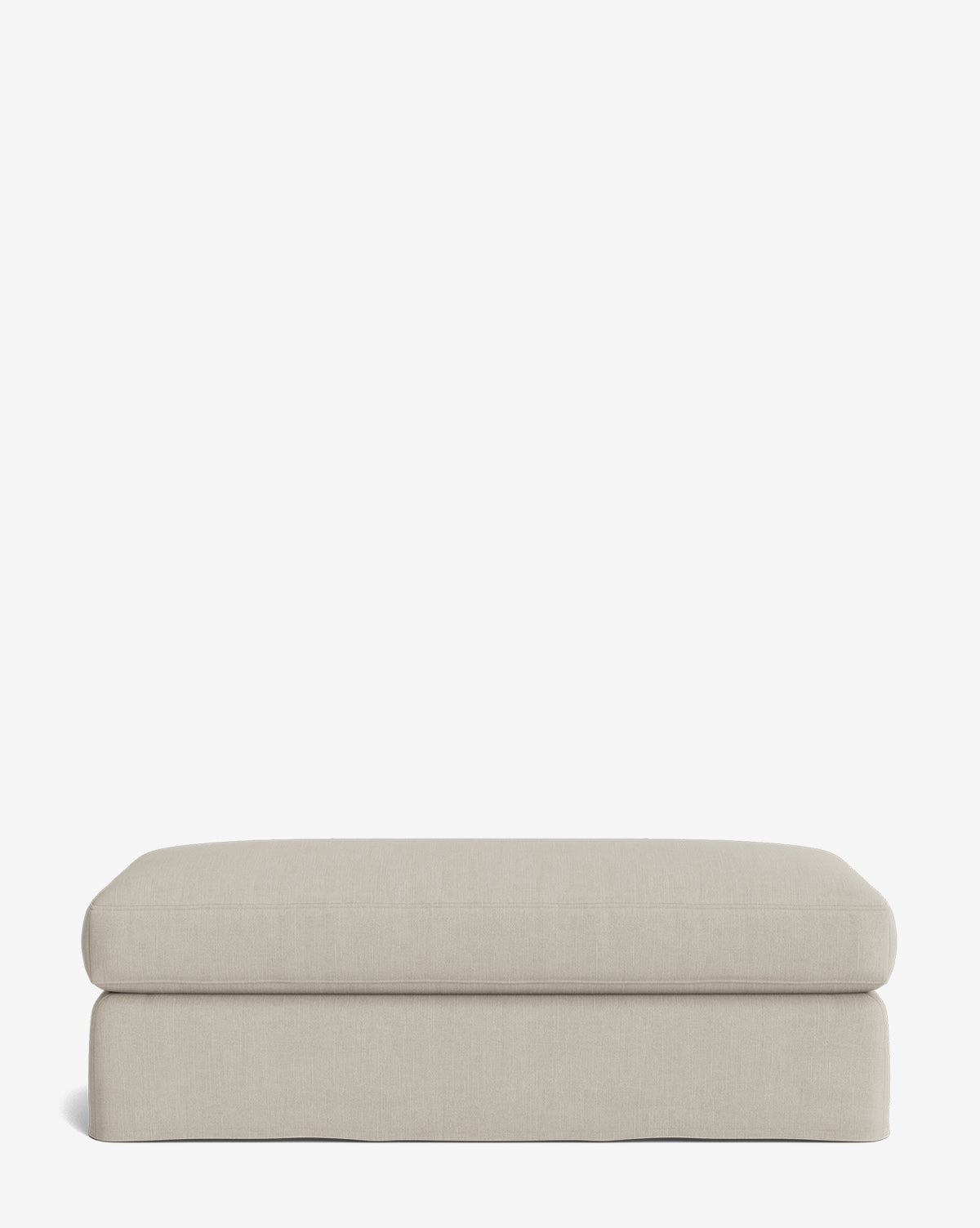 The Macy Slipcover Ottoman is a rectangular, light beige piece with rounded edges, shown against a white background—ideal as versatile living room furniture, by Vendixs