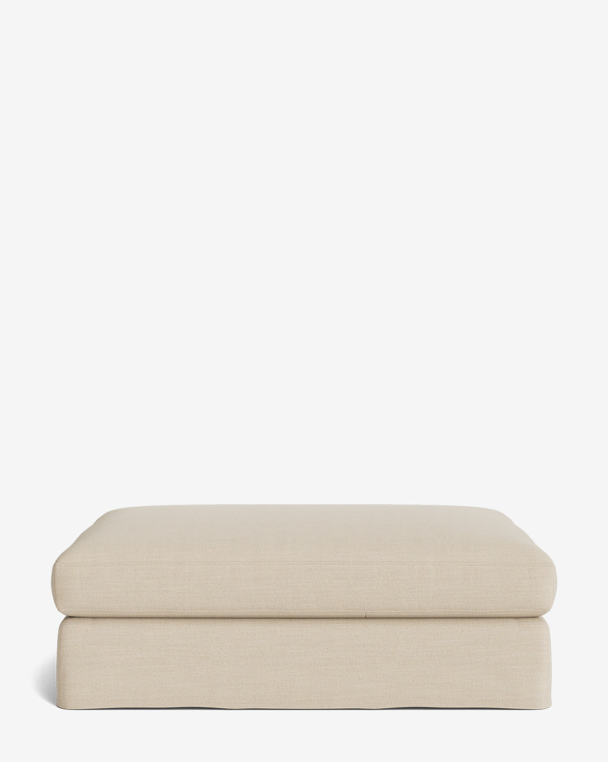 The Macy Slipcover Ottoman is a minimalist rectangular ottoman in beige with smooth edges and a cushioned top, ideal as customizable living room furniture, by Vendixs Shown against a plain white background.