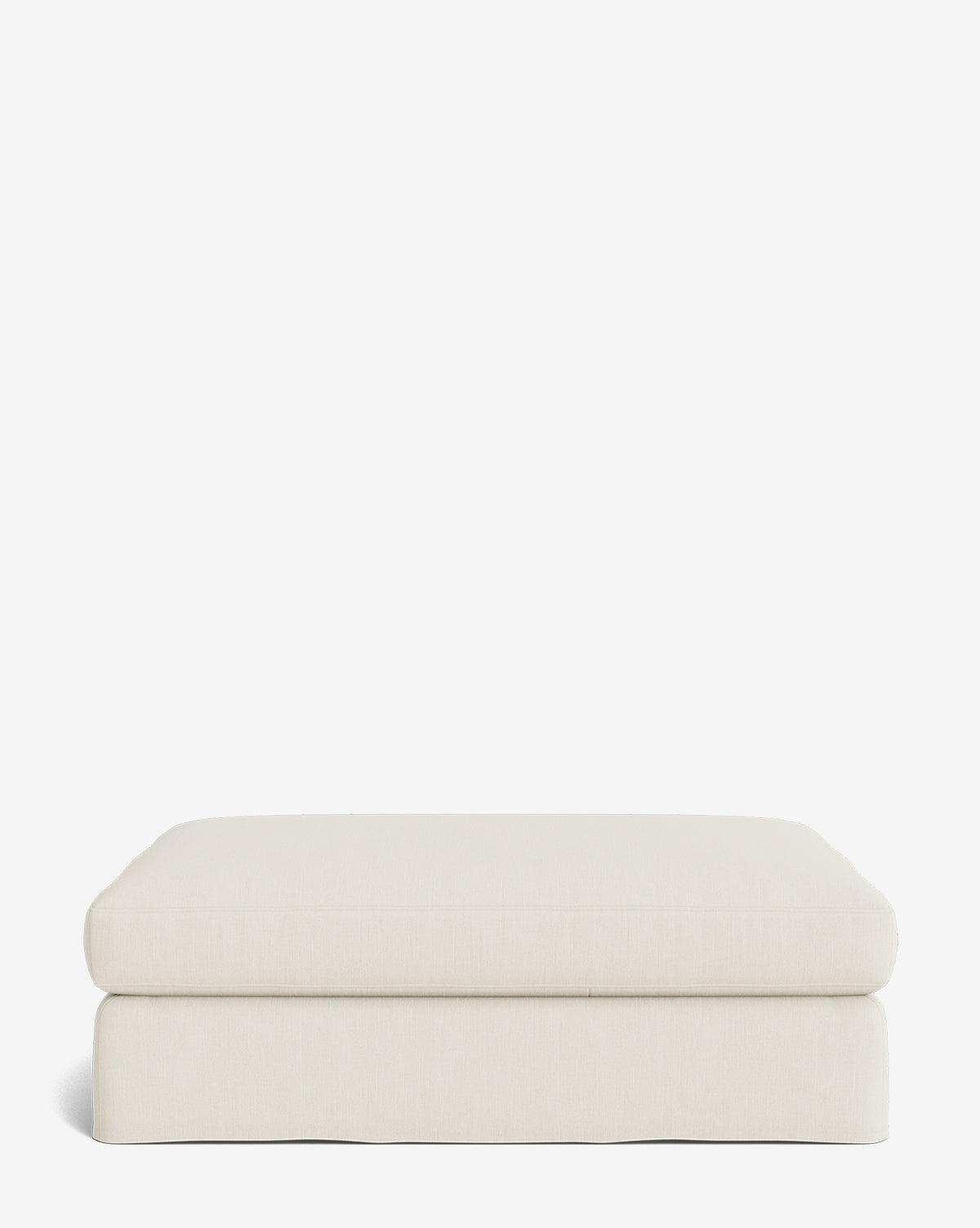 The Macy Slipcover Ottoman features light beige fabric, soft rounded edges, and a minimalist low-profile design, making it ideal as customizable living room furniture against a plain white background, by McGee & Co.