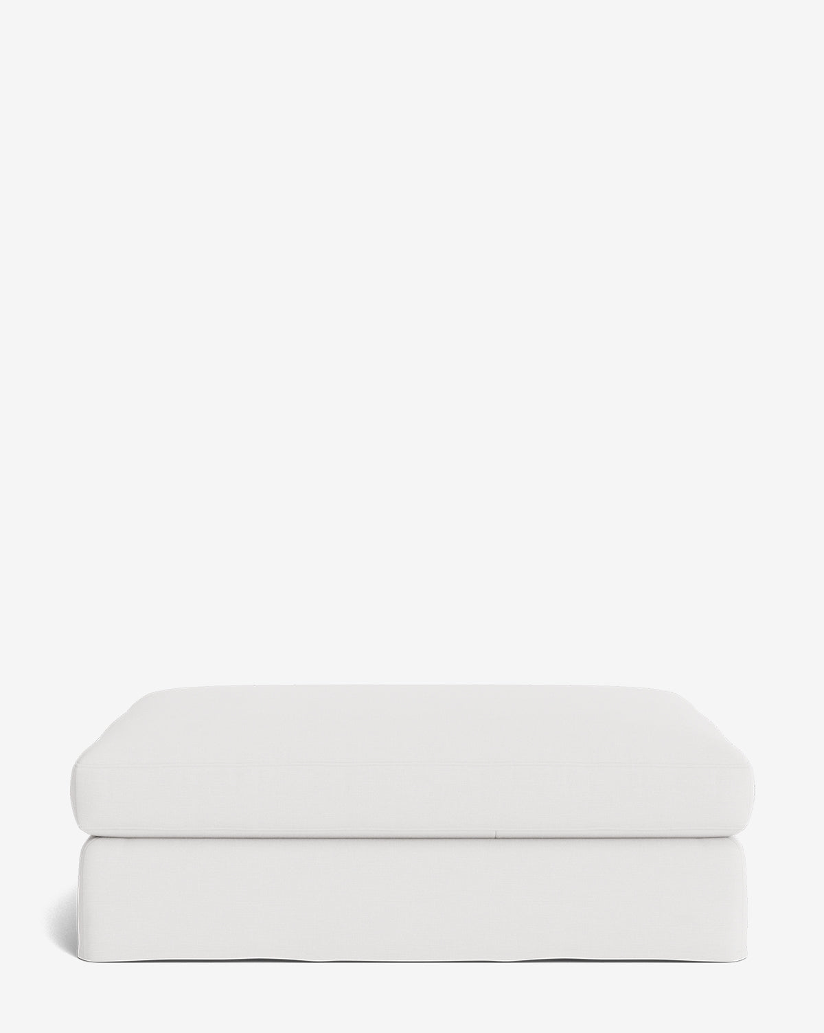 The Macy Slipcover Ottoman is a rectangular, white upholstered piece with soft, rounded edges and a smooth minimalist design—customizable and versatile, perfect for any living room, by McGee & Co.