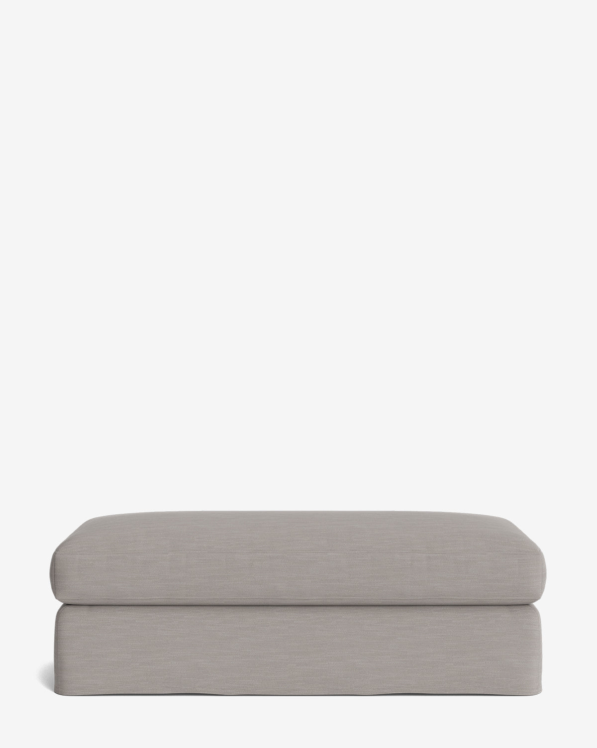 The Macy Slipcover Ottoman is a rectangular, light gray ottoman with smooth edges and a minimalist design, perfect for living room spaces, by Vendixs Shown against a plain white background.