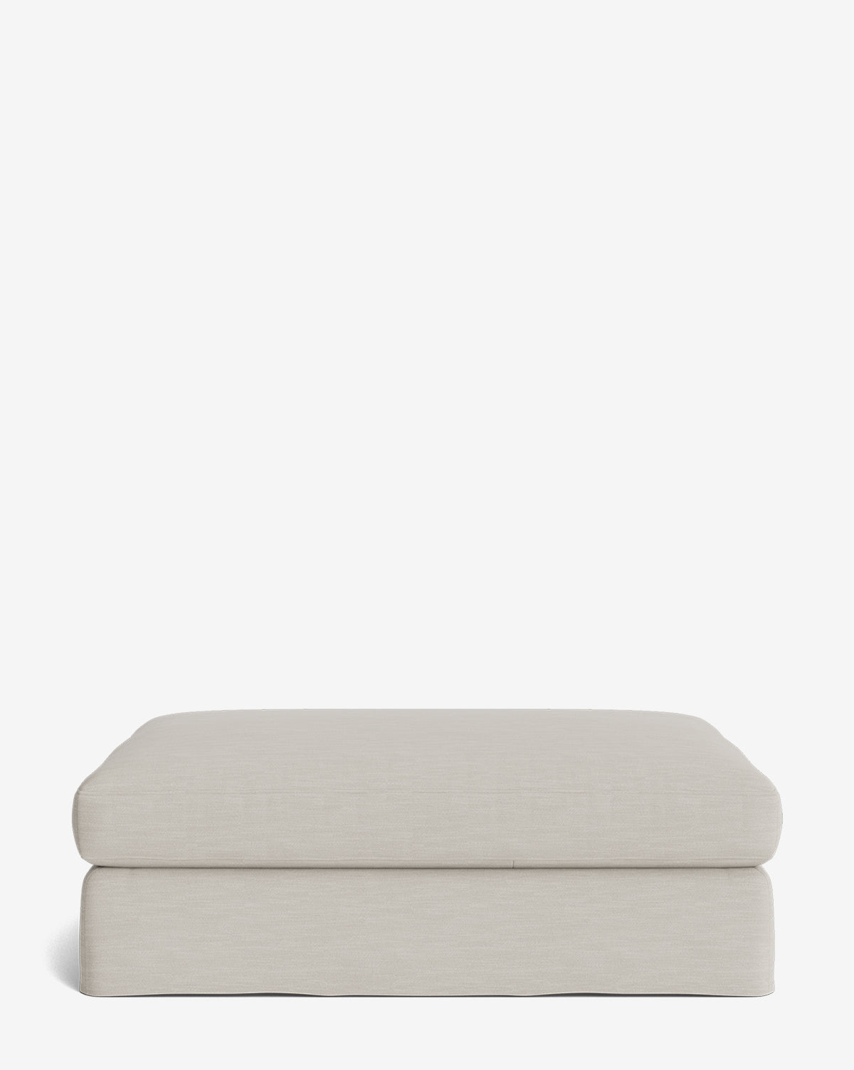 The Macy Slipcover Ottoman is a beige rectangular piece with a minimalist design and soft fabric upholstery, ideal for living rooms, shown against a plain white background, by Vendixs