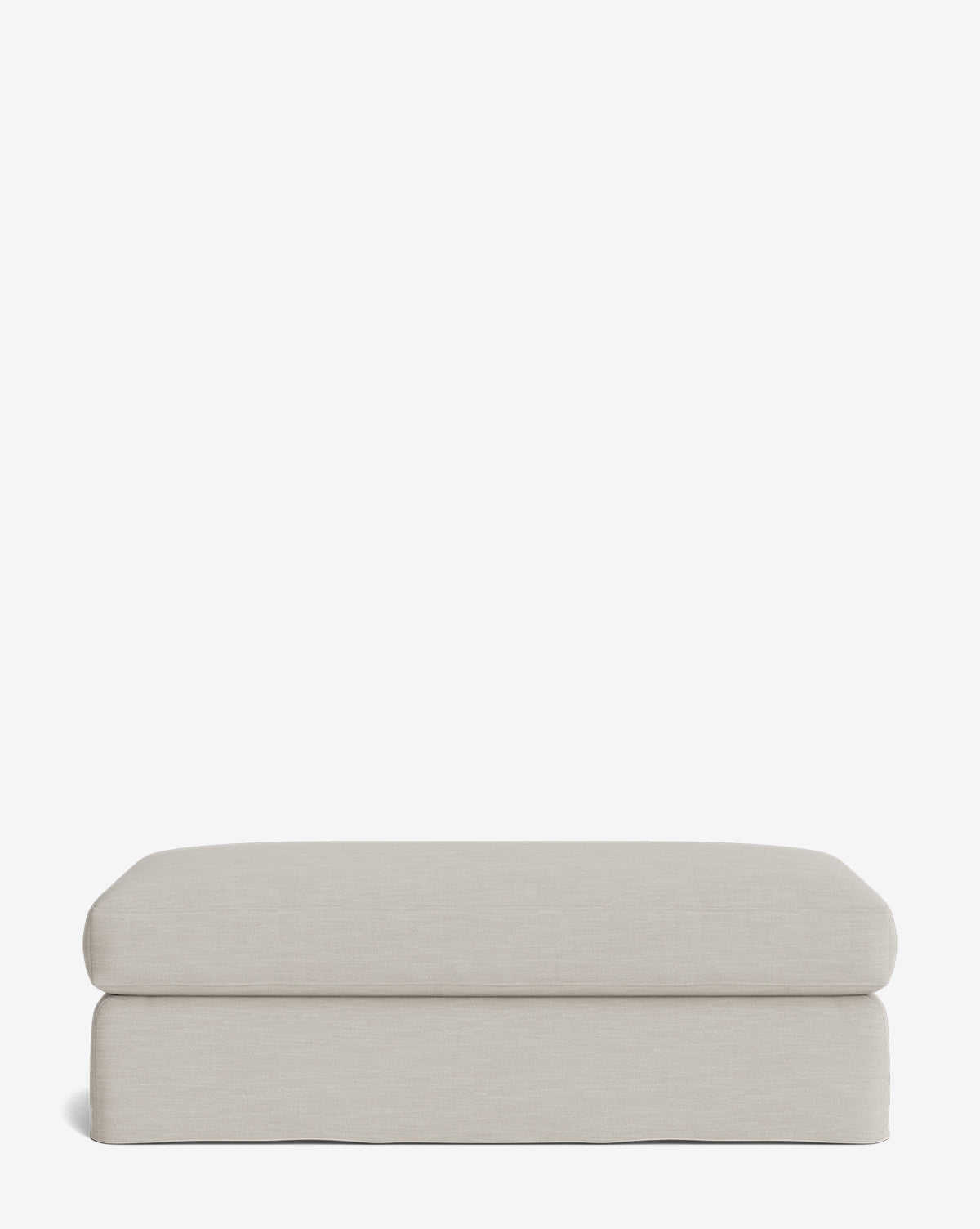 The Macy Slipcover Ottoman features a rectangular, light beige design with soft, rounded edges and a smooth surface—an inviting addition to your living room, shown against a plain white background, by Vendixs