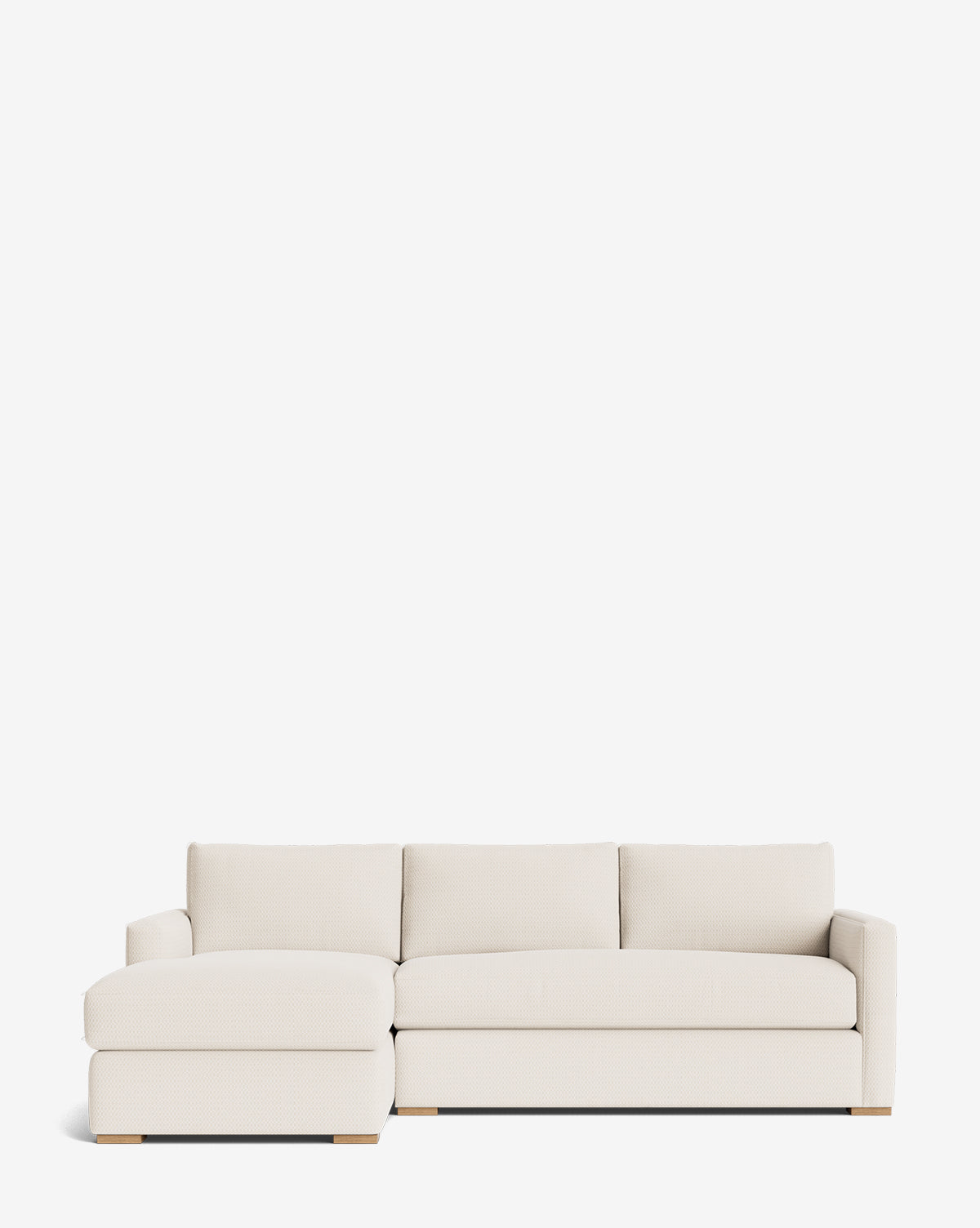 The Community Macy Upholstered Chaise Sectional 101 features a modern, light beige design with clean lines, low wooden legs, and a left-side chaise lounge, shown against a plain white background. Vendixs