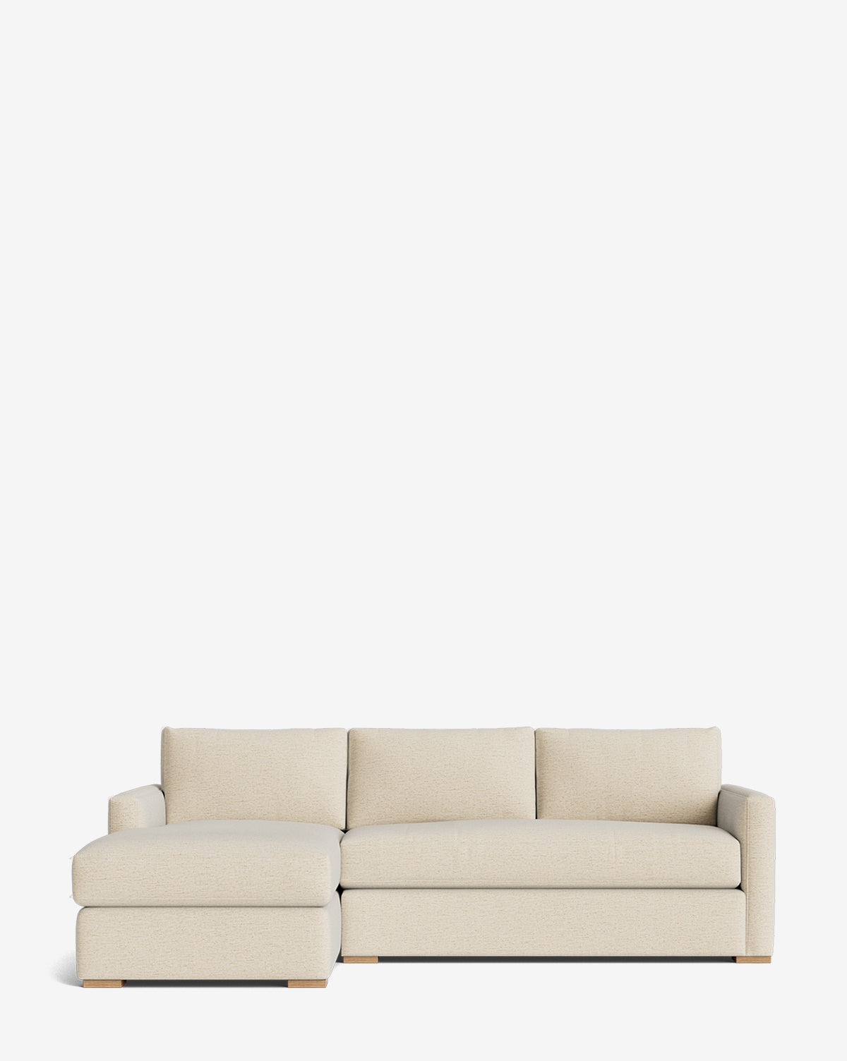 The Macy Upholstered Chaise Sectional 101 by Community features a beige finish, left-side upholstered chaise lounge, three back cushions, and low wooden block legs, shown against a plain white background. Vendixs