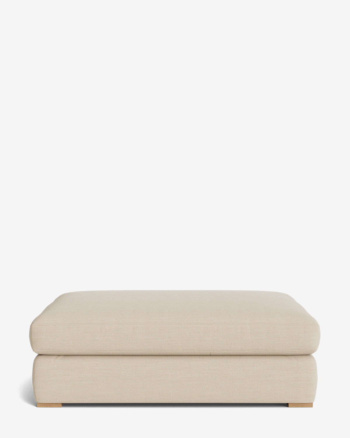 The Macy Upholstered Ottoman features a rectangular shape, light beige upholstery, rounded edges, low wooden feet, and a minimalistic design. Customizable for your space, it adds style to any living room and is shown against a plain white background by McGee & Co.