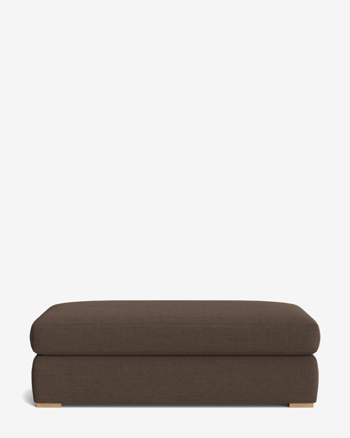 The Macy Upholstered Ottoman features a rectangular, brown upholstered design with low wooden feet and a modern look, perfect for enhancing your living room. Shown here against a plain white background by McGee & Co.