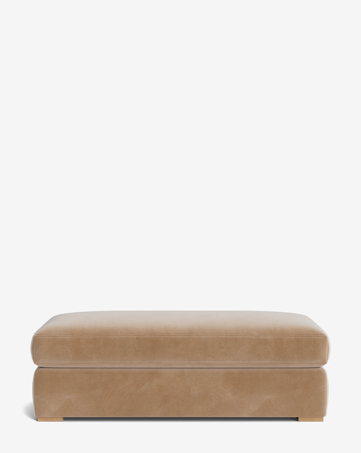 The Macy Upholstered Ottoman features a rectangular, tan design with a cushioned top and gold-accented corners—an elegant addition to any living room, shown against a plain white background by McGee & Co.