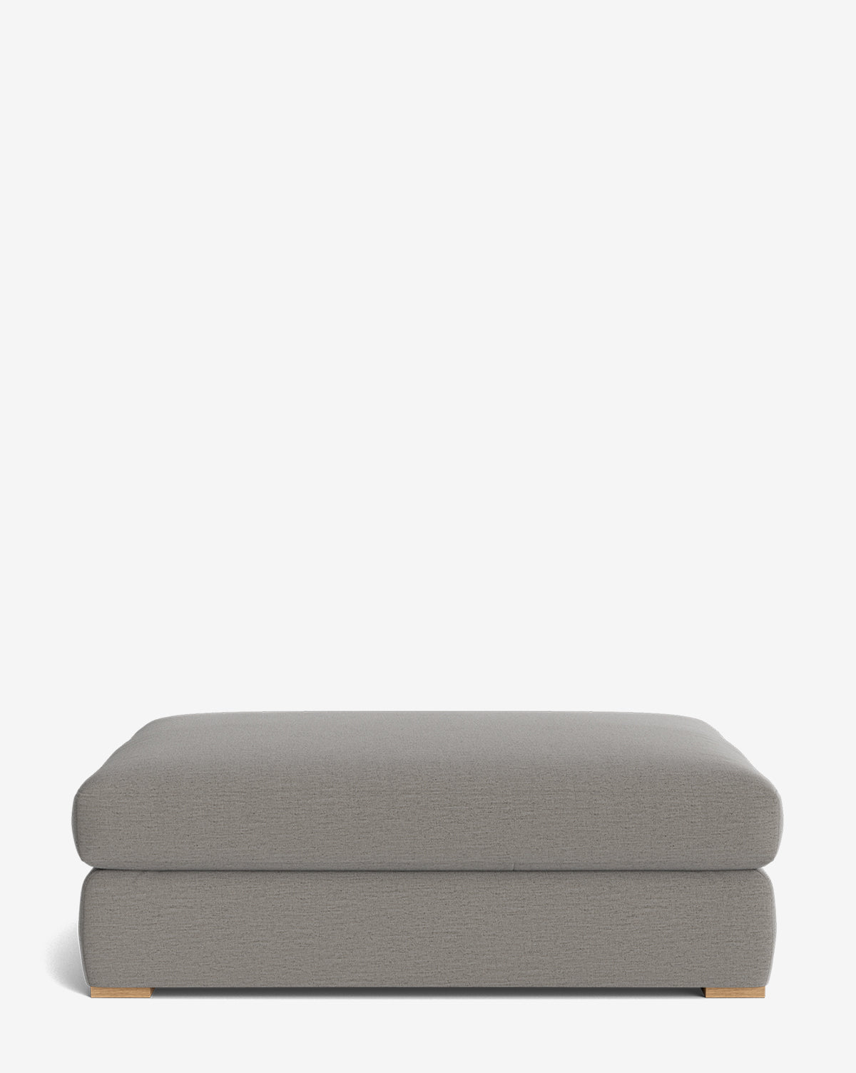 The Macy Upholstered Ottoman features a rectangular, light gray design with slightly rounded edges and short wooden feet, making it a versatile living room piece, by McGee & Co. Shown against a plain white background.