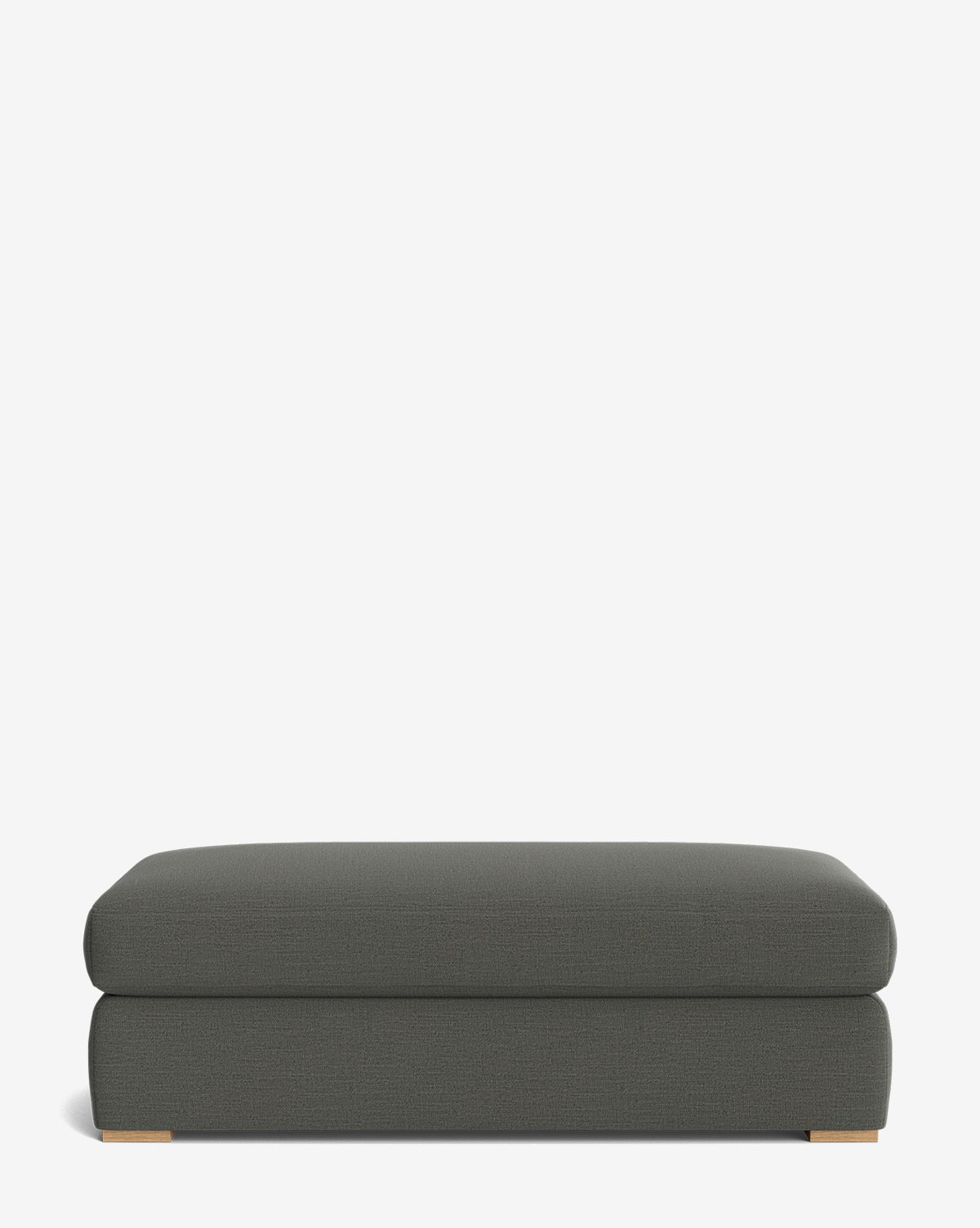 The Macy Upholstered Ottoman is a rectangular, dark gray piece with short wooden feet, ideal for living rooms and shown against a plain white background, by McGee & Co.