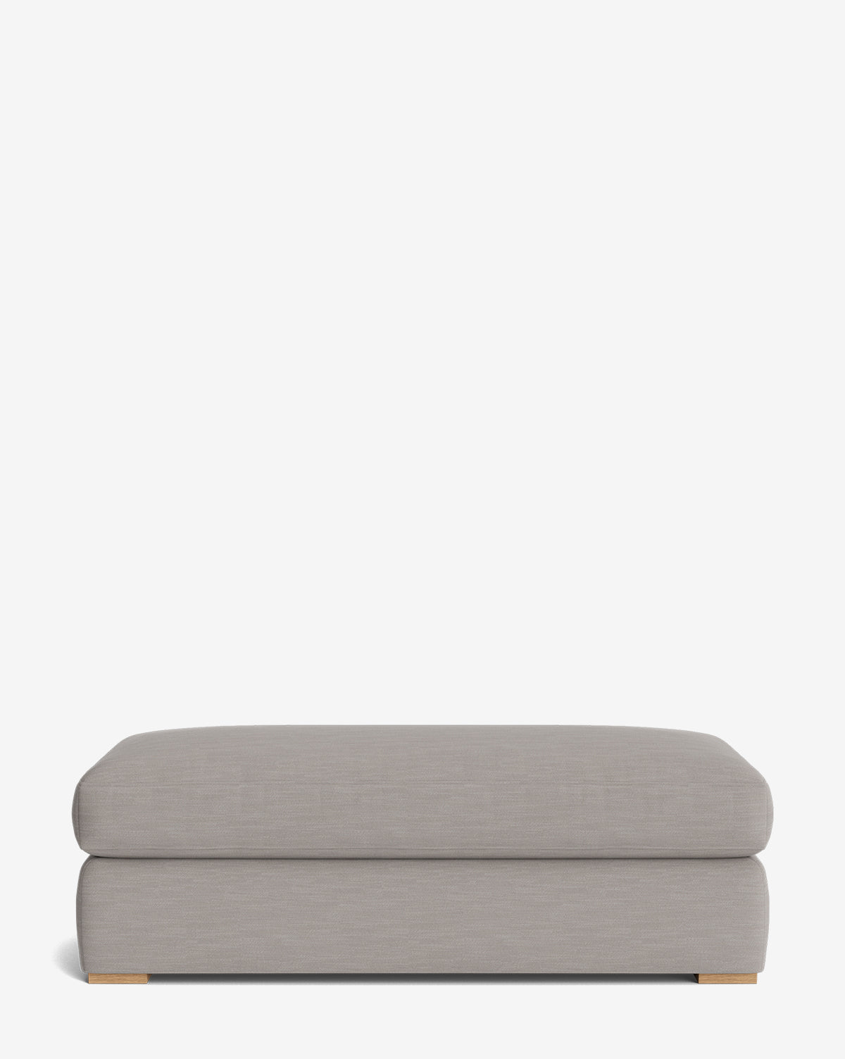 The Macy Upholstered Ottoman is a modern, rectangular grey piece with a cushioned top and low wooden feet, ideal as versatile living room furniture, by McGee & Co. Shown against a plain white background.