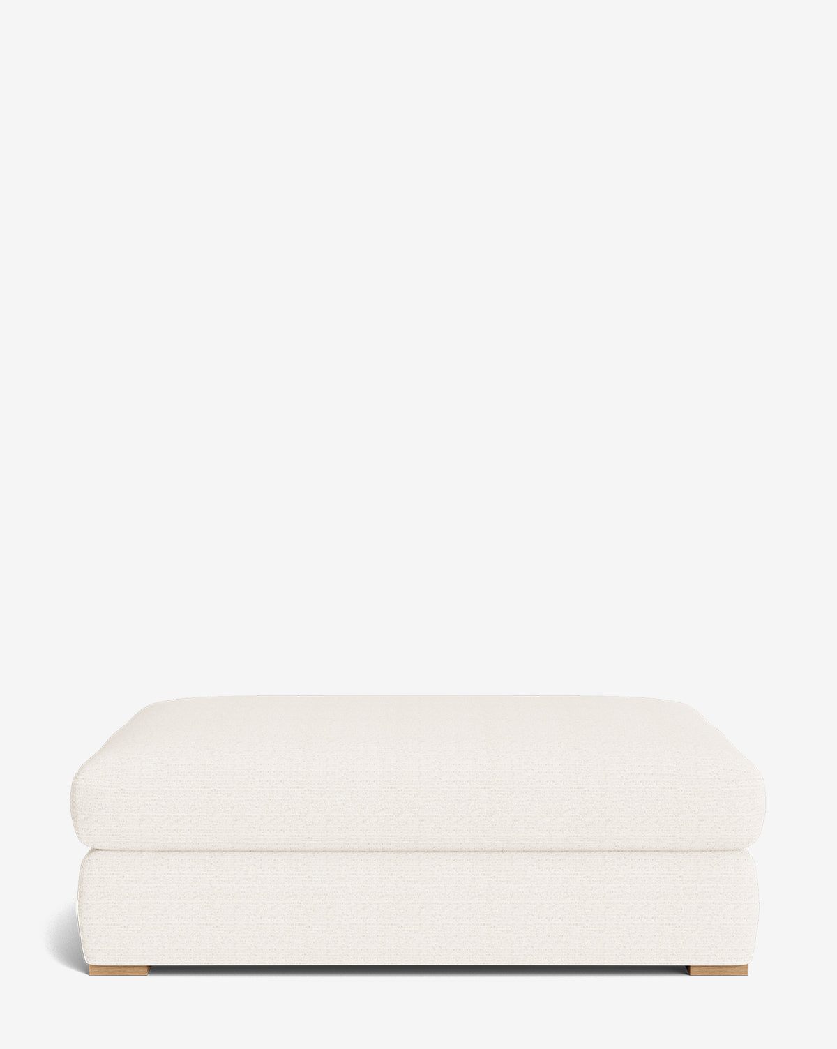 The Macy Upholstered Ottoman is a rectangular, low-profile piece in off-white fabric with wooden base accents, showcasing a simple modern design—an elegant addition to your living room, displayed against a plain white background by McGee & Co.