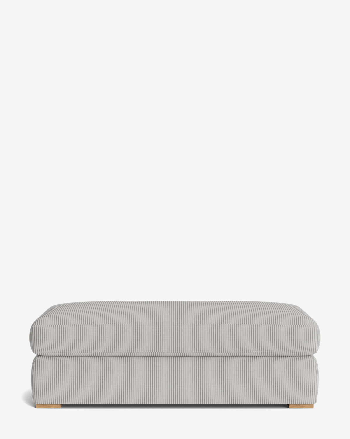 The Macy Upholstered Ottoman features a rectangular shape with light gray and white vertical pinstripes, a cushioned top, and low wooden feet. Customizable and stylish, its perfect for adding comfort to your living room décor, by Vendixs