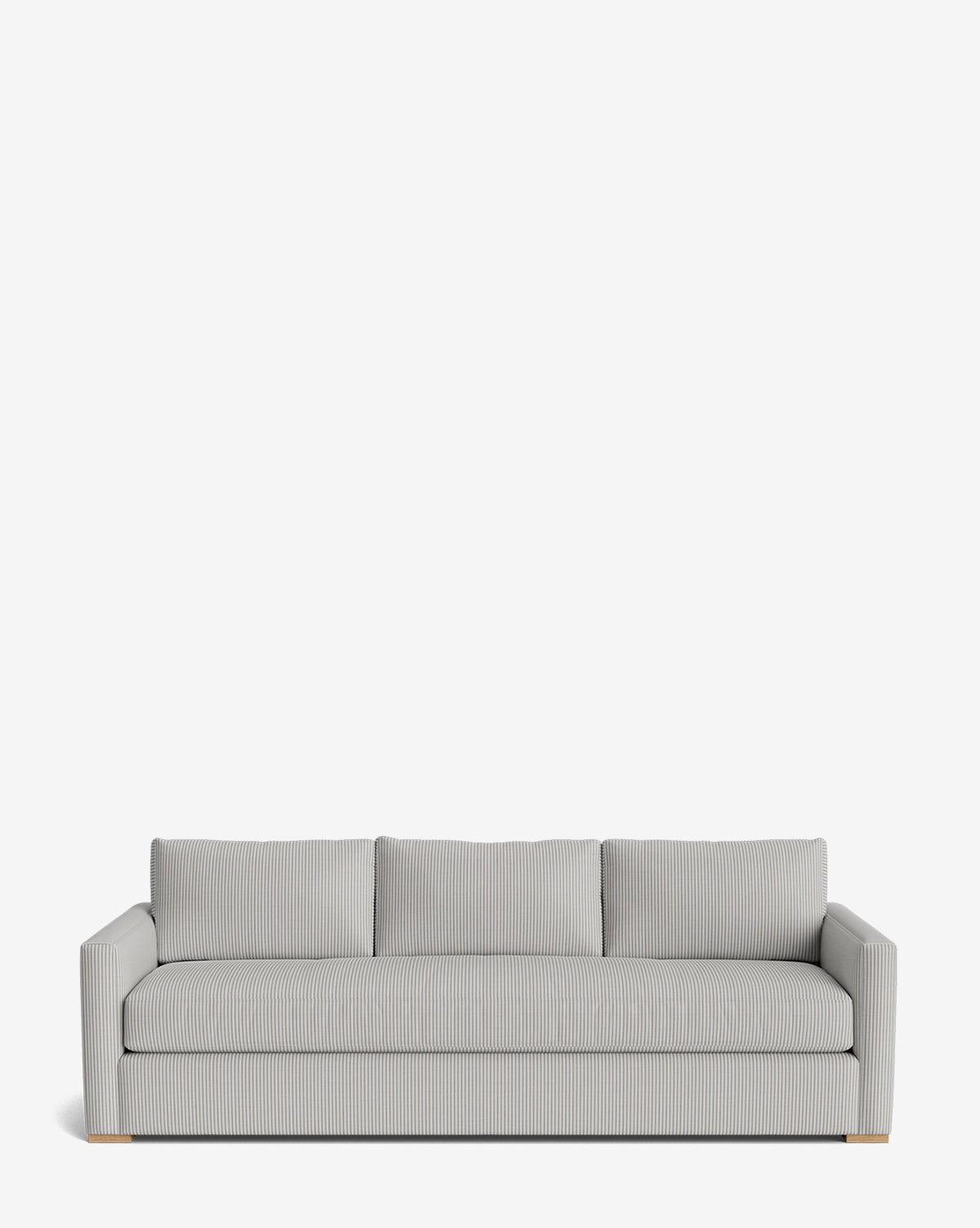 The Macy Upholstered Sofa (84-96) is a modern, light gray piece with three seat and back cushions, subtle vertical stripes, low square arms, and small light wooden feet. Perfect for any living room, shown here against a plain white background by McGee & Co.
