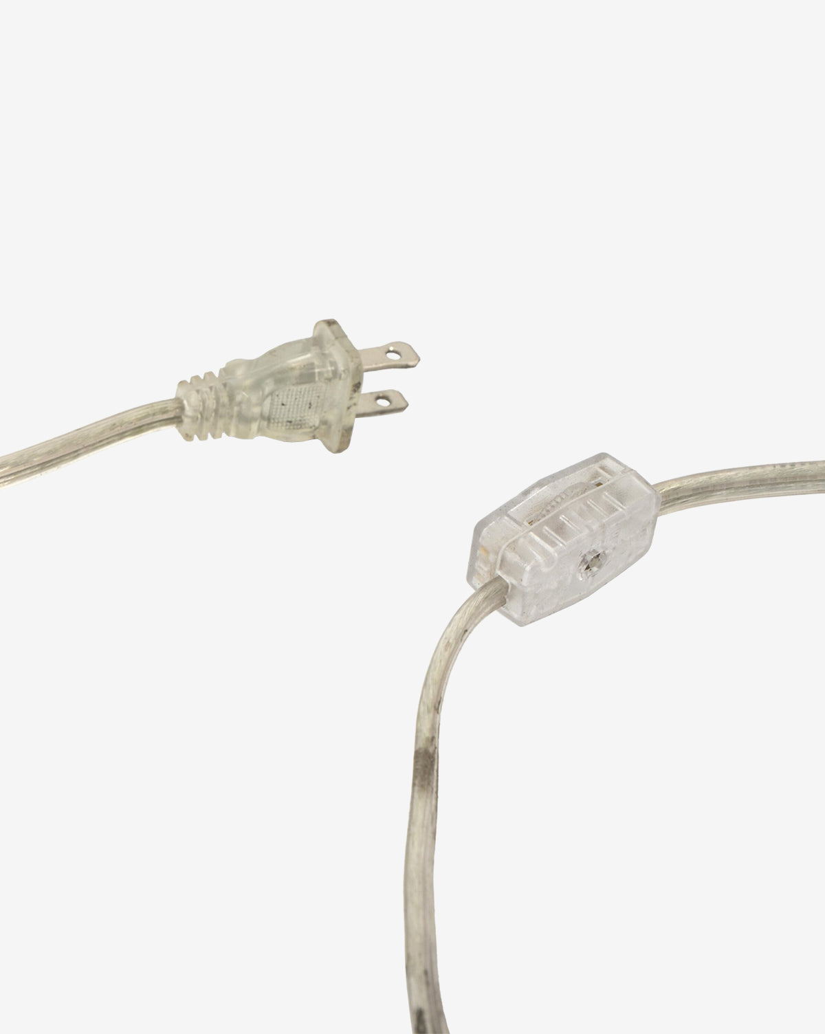 The Malinska Table Lamp features a transparent electrical plug and cord with an inline switch, all made of clear plastic—ideal for pairing with an Italian marble base and a linen dome shade, shown against a plain white background, by Vendixs