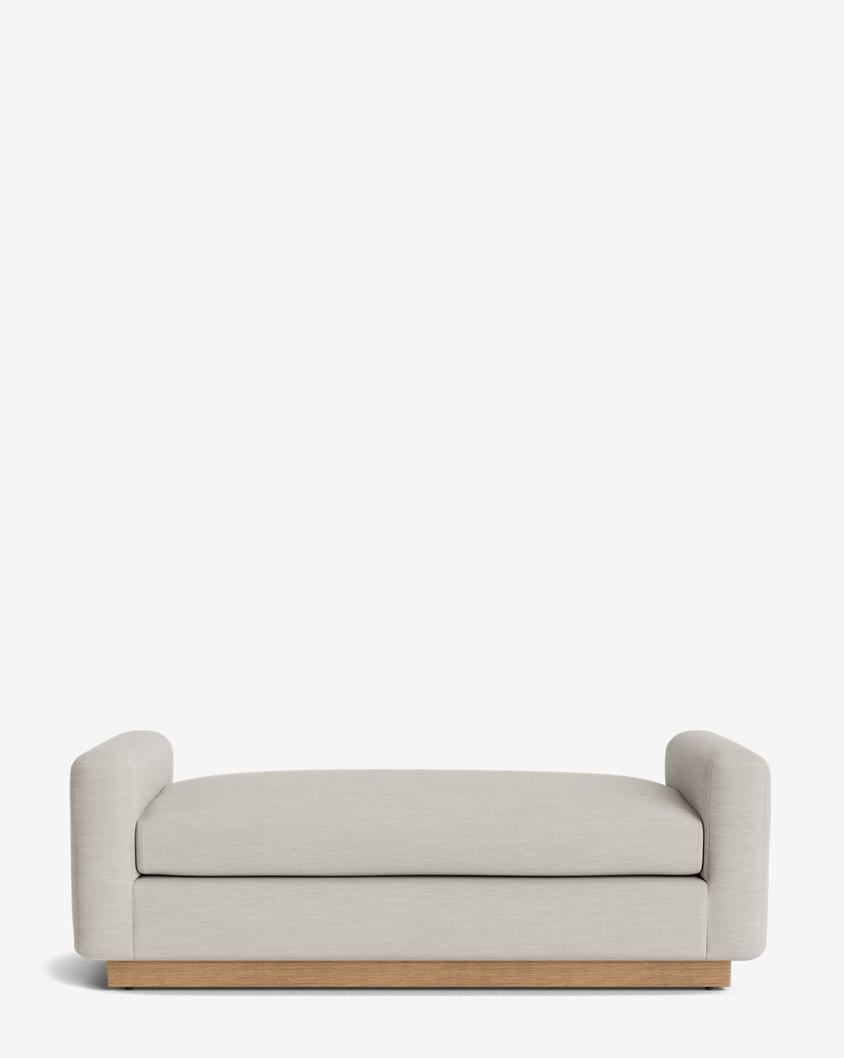 The Mansfield Bench is a modern, minimalist bench in light beige upholstery with low, rounded arms on each side and a wooden base, by Vendixs