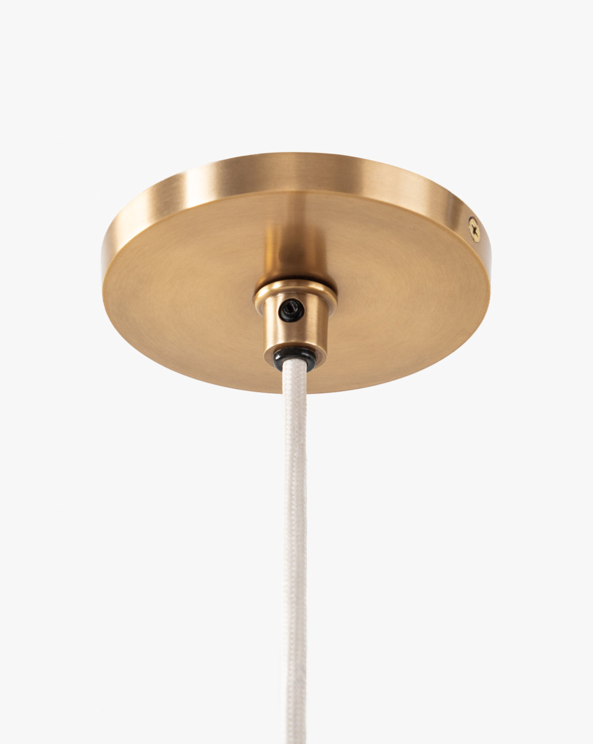 A close-up of a round, brushed brass ceiling canopy with brass hardware and white cord, designed to pair with the Vendixs x Loeffler Randall Maude Glass Pendant, shown against a plain white background, by Vendixs