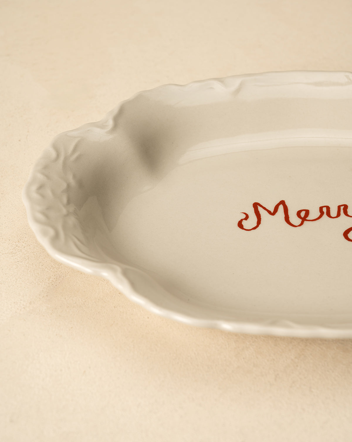 Resting on a light beige surface, this festive white serving platter is perfect for holiday table decor, by Vendixs