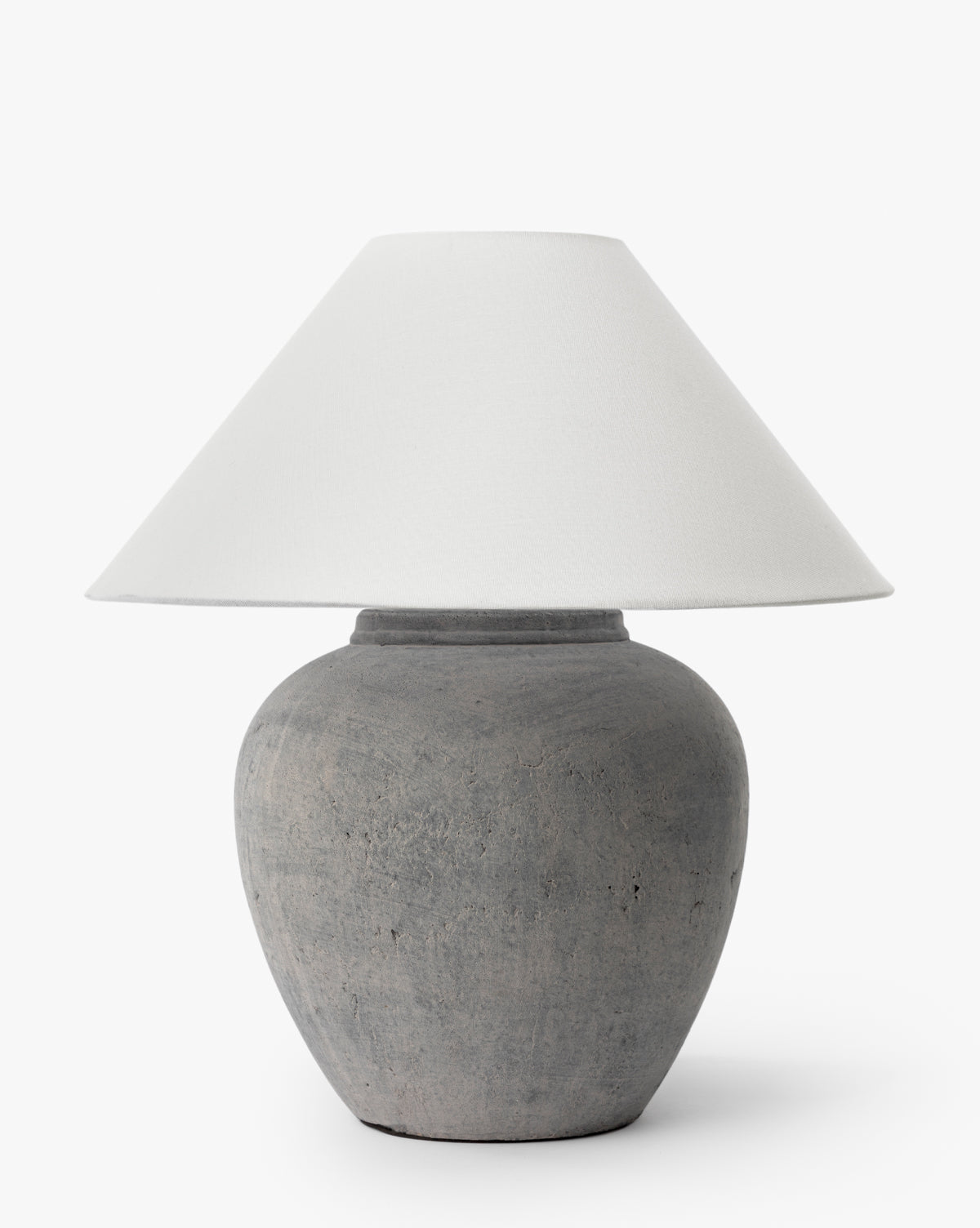 The Montague Table Lamp features a rounded, textured gray ceramic base and a wide, white conical shade, standing out against a plain white background by McGee & Co.