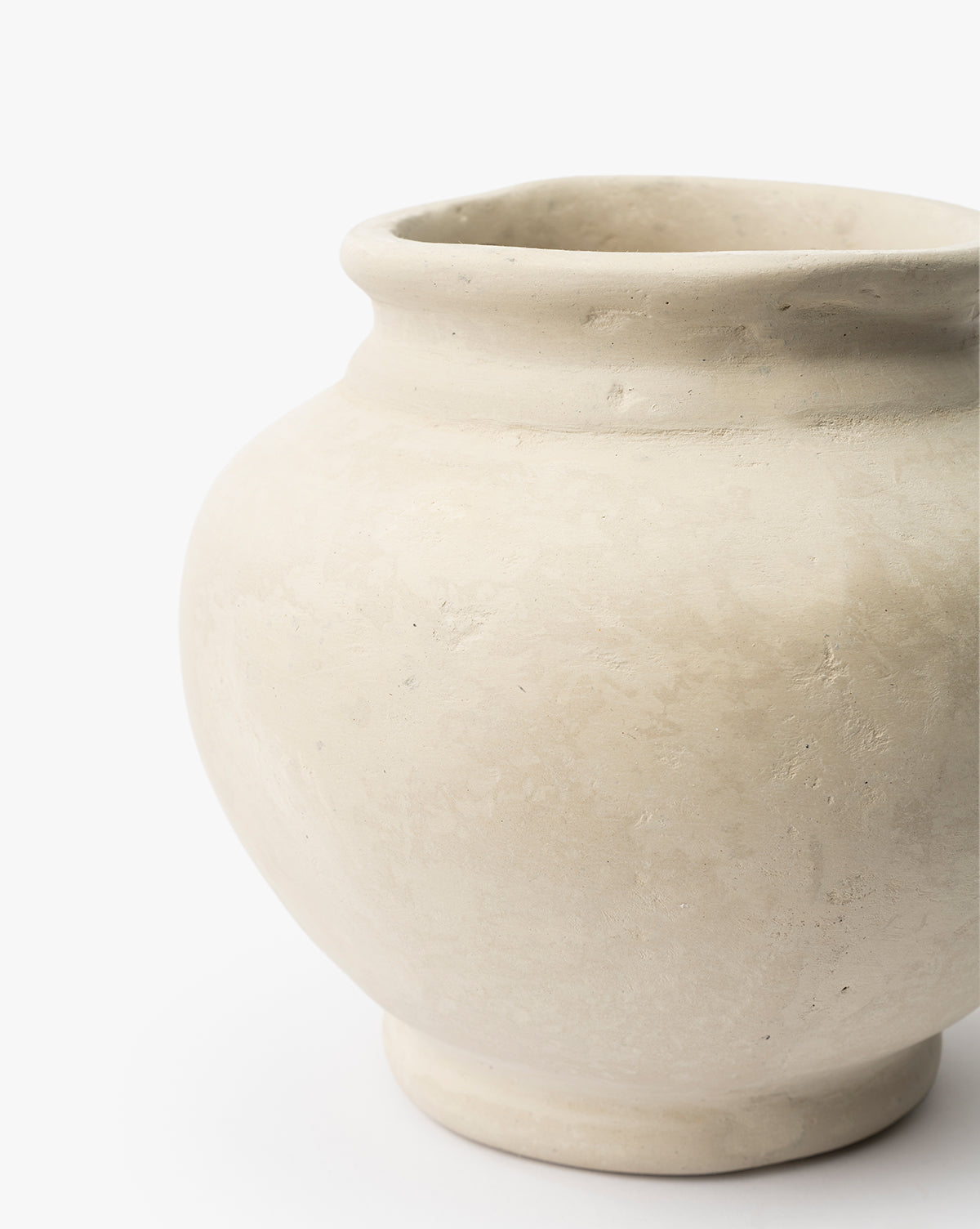 A close-up of the Nola Paper Mache Vase—a round, cream-colored piece with a wide opening and subtle textured finish—set against a plain white background, by Vendixs
