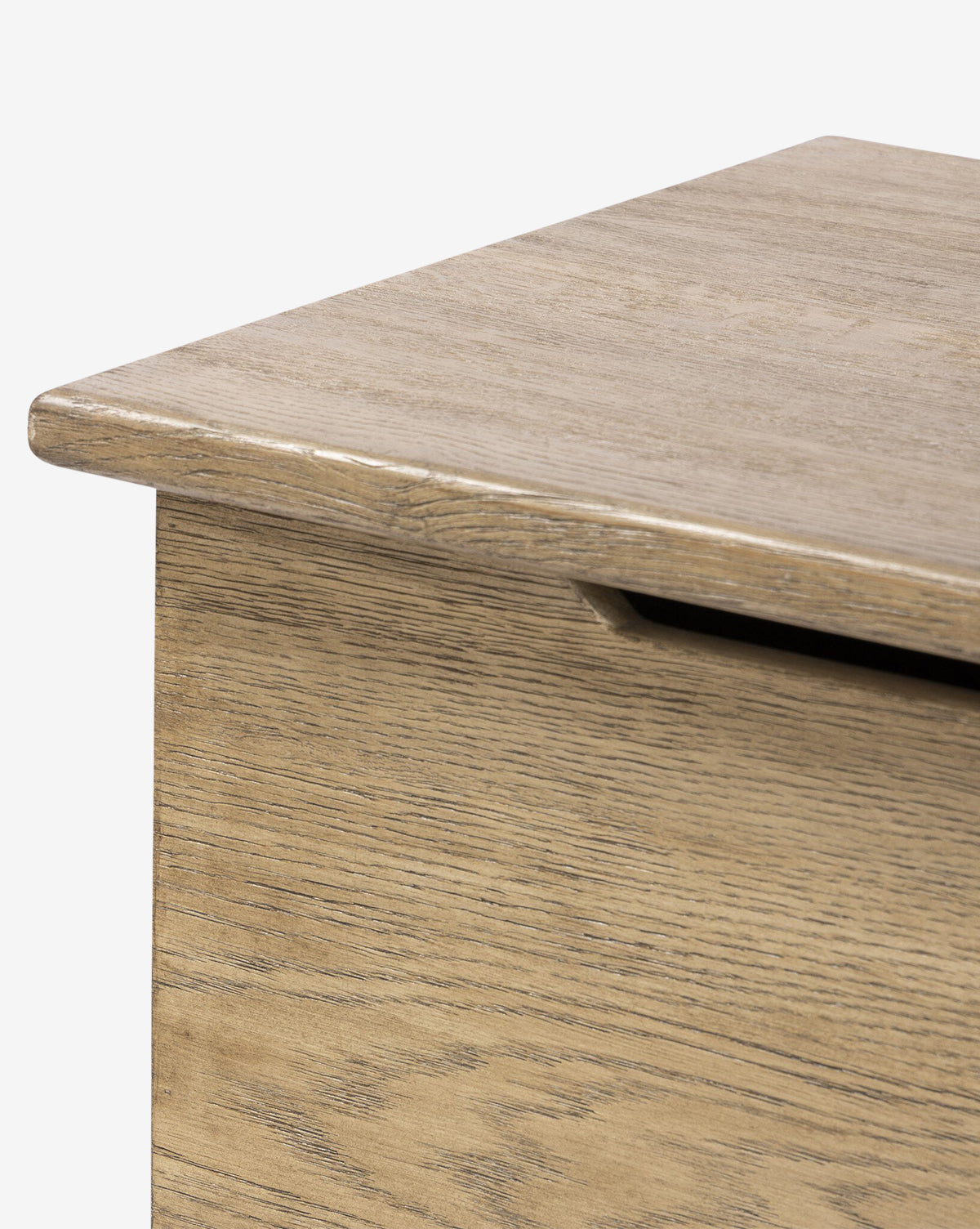 Close-up of the Norman Bench by Four Hands, showing the solid oak corner with a smooth, flat lid and a cutout handle beneath the edge for easy access. Vendixs