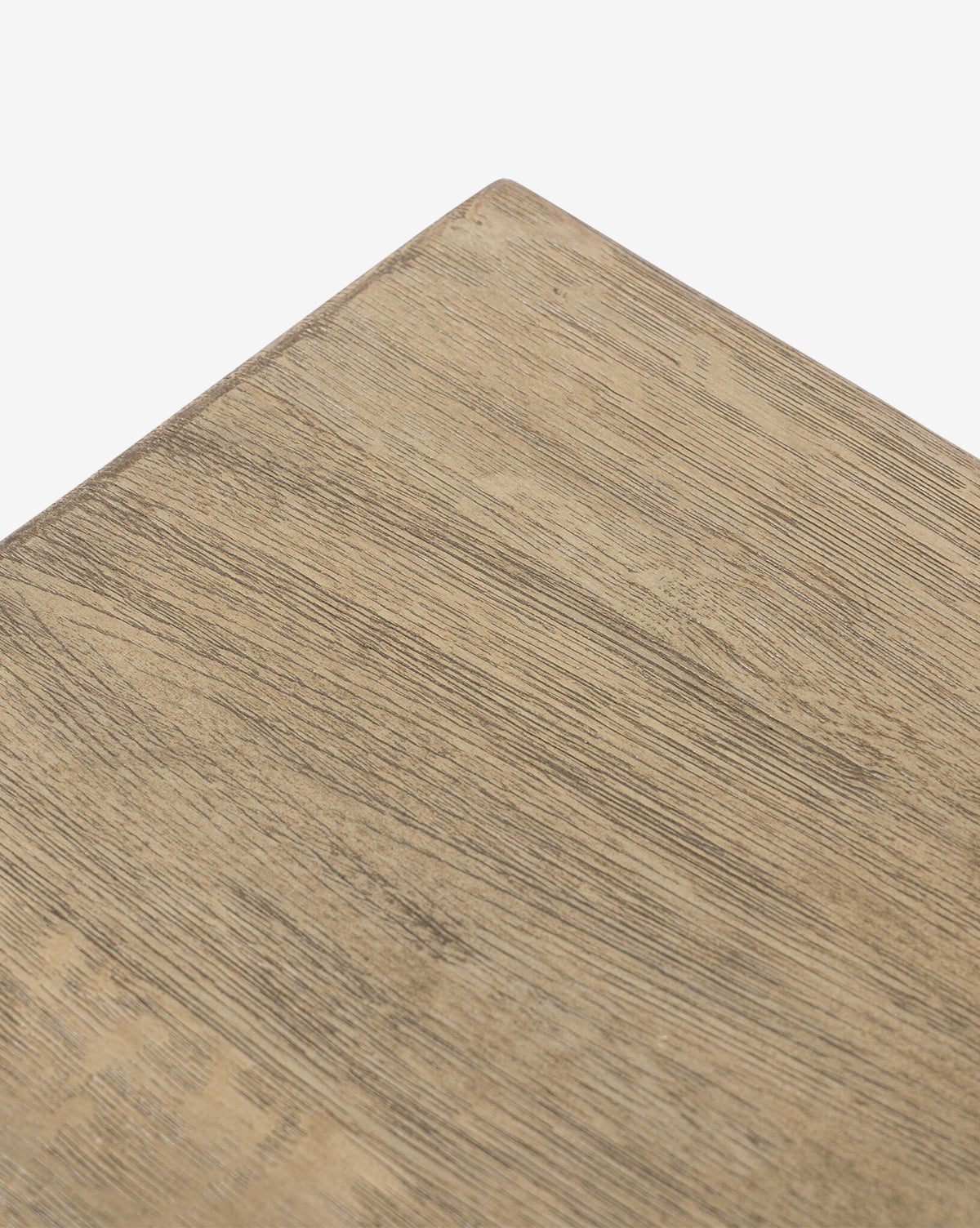 Close-up of the corner of the Four Hands Norman Bench, featuring solid oak with a light brown finish and visible wood grain, set against a plain white background. Vendixs