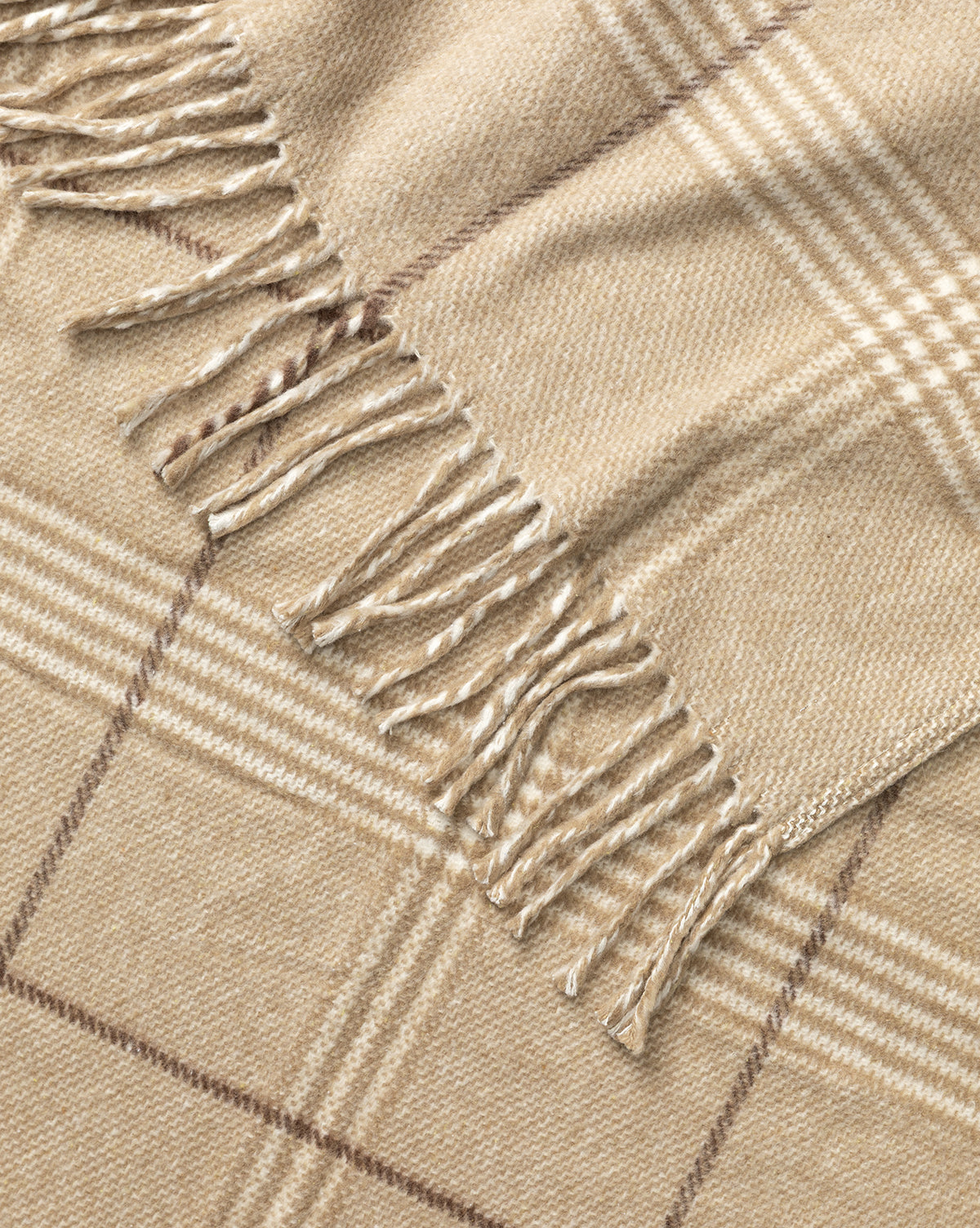 A close-up of the Nottingham Throw by J Call Designs LLC dba Sew Miami LLC, showcasing its beige plaid pattern with fringed edges and intersecting light and dark brown lines for a classic, cozy appearance. Vendixs