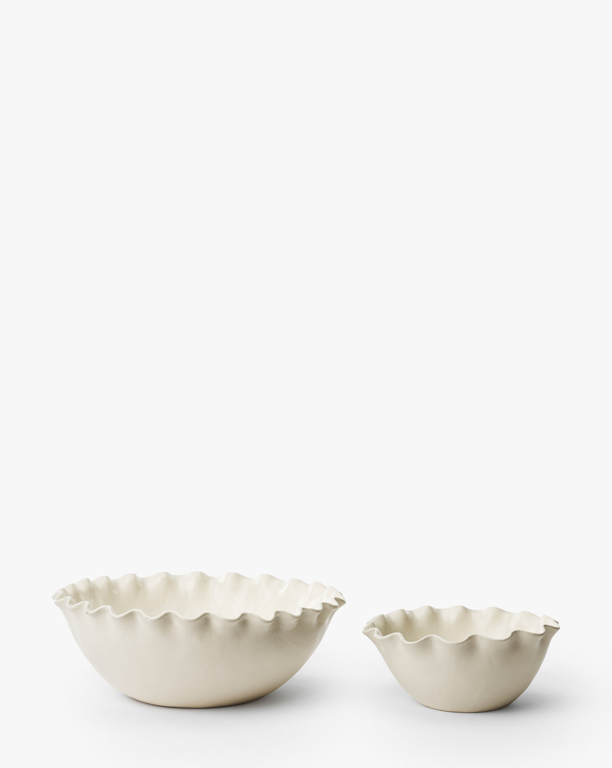 The Olindo Serving Bowls (Set of 2), featuring ivory coloring and wavy ruffled edges in two sizes, are displayed on a plain white background, bringing a vintage-inspired accent to your stoneware collection, by Vendixs