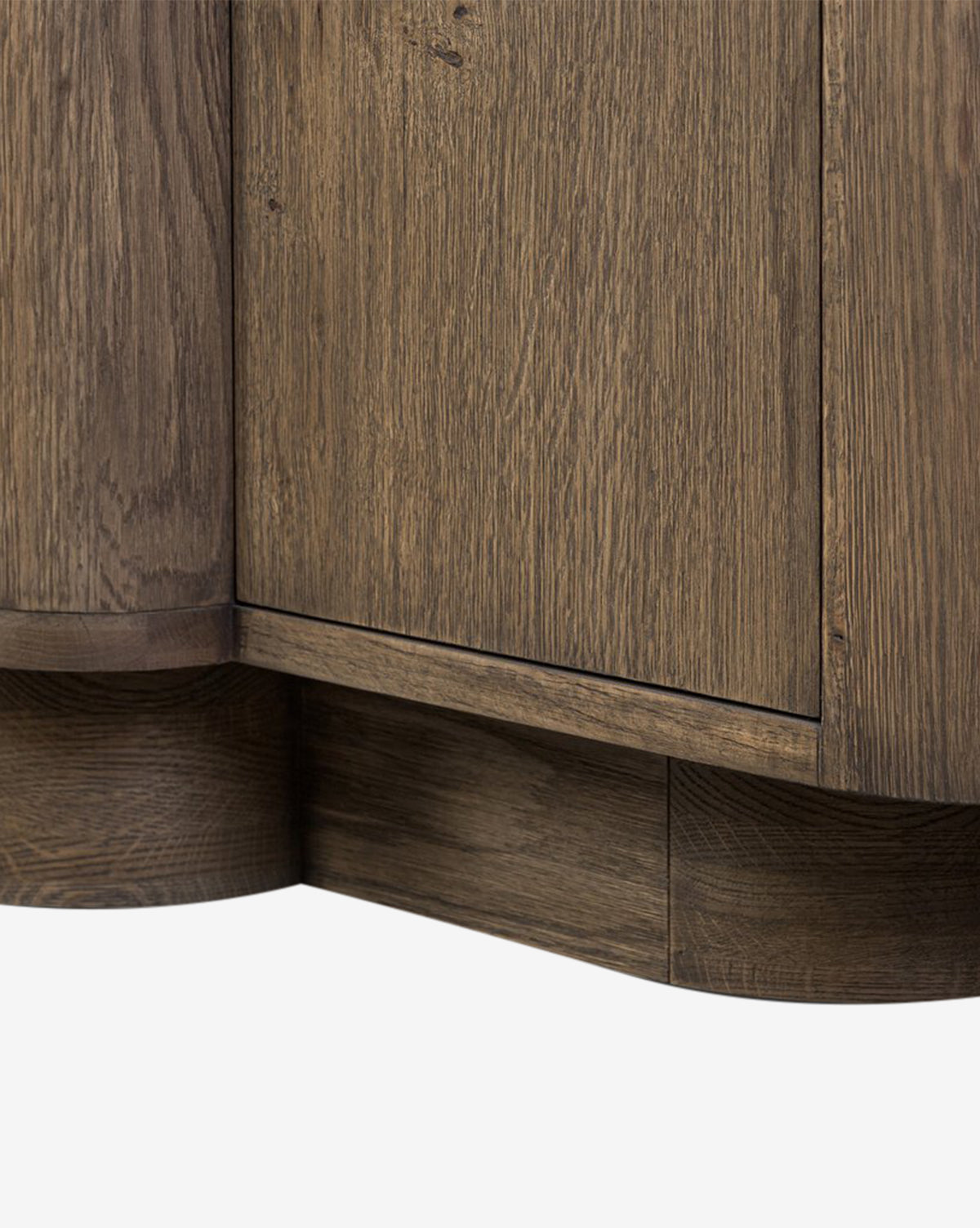 Close-up of the lower corner of the Oswin Sideboard, displaying its weathered oak finish, visible wood grain, and rounded base details against a white background, by Vendixs