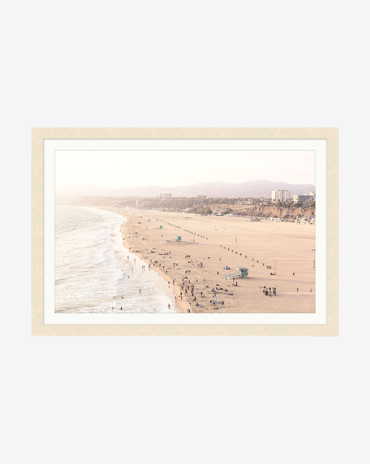 Framed giclee print Pacific Perspective—a wide sandy beach with scattered people, gentle waves, and distant buildings under a hazy sky in a natural wood frame, by Vendixs