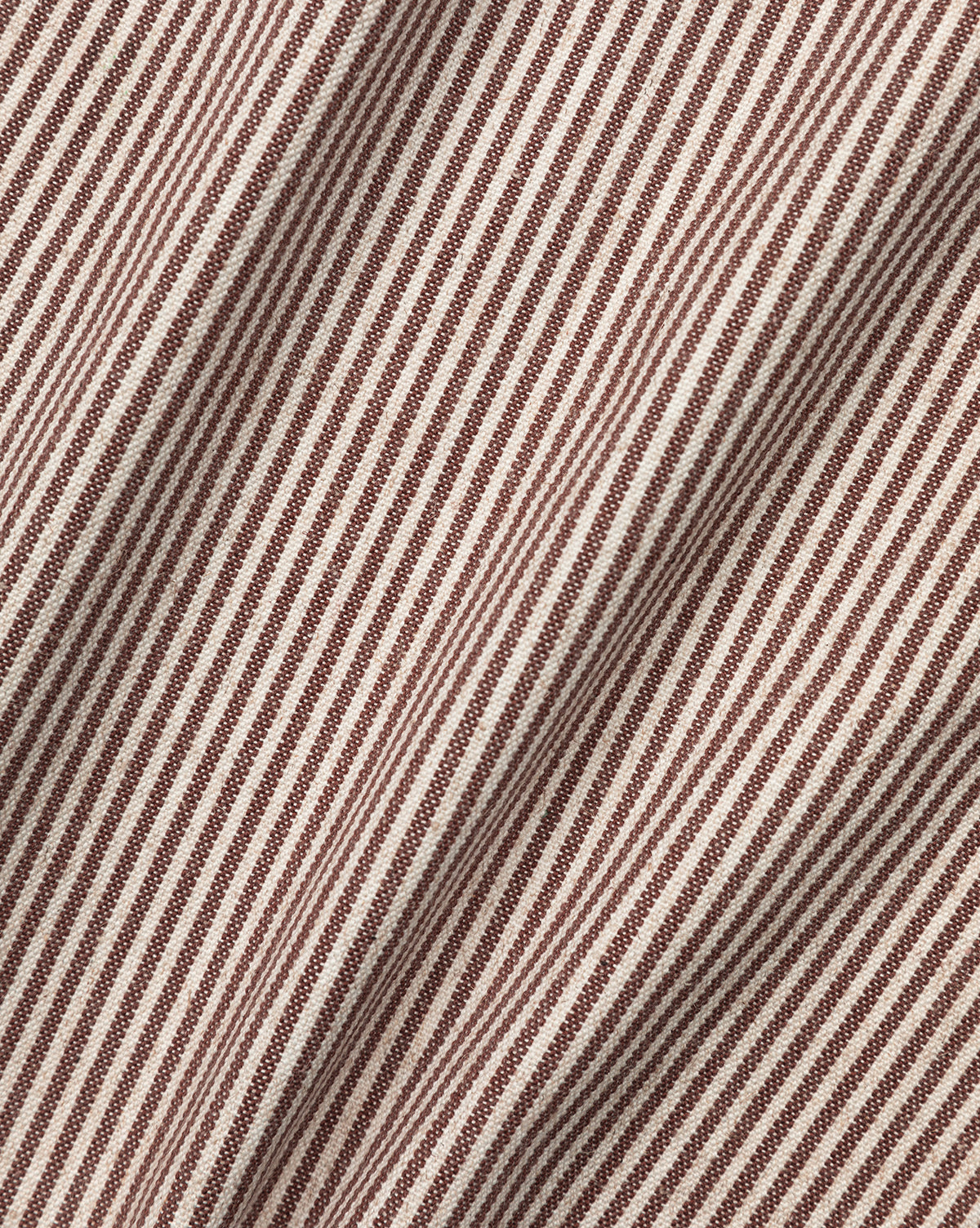 Close-up of Makerspalm Palladio Bed Brown & Ivory Classic Swatch fabric, featuring diagonal brown and ivory ticking stripes with visible folds and texture—ideal for adding depth and movement to an upholstered headboard. Vendixs