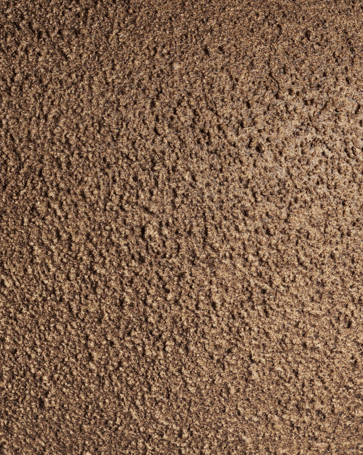 Close-up of a rough, brown, crumbly surface with uneven, grainy texture, similar to the naturally textured ceramic base of the Parma Table Lamp by Vendixs