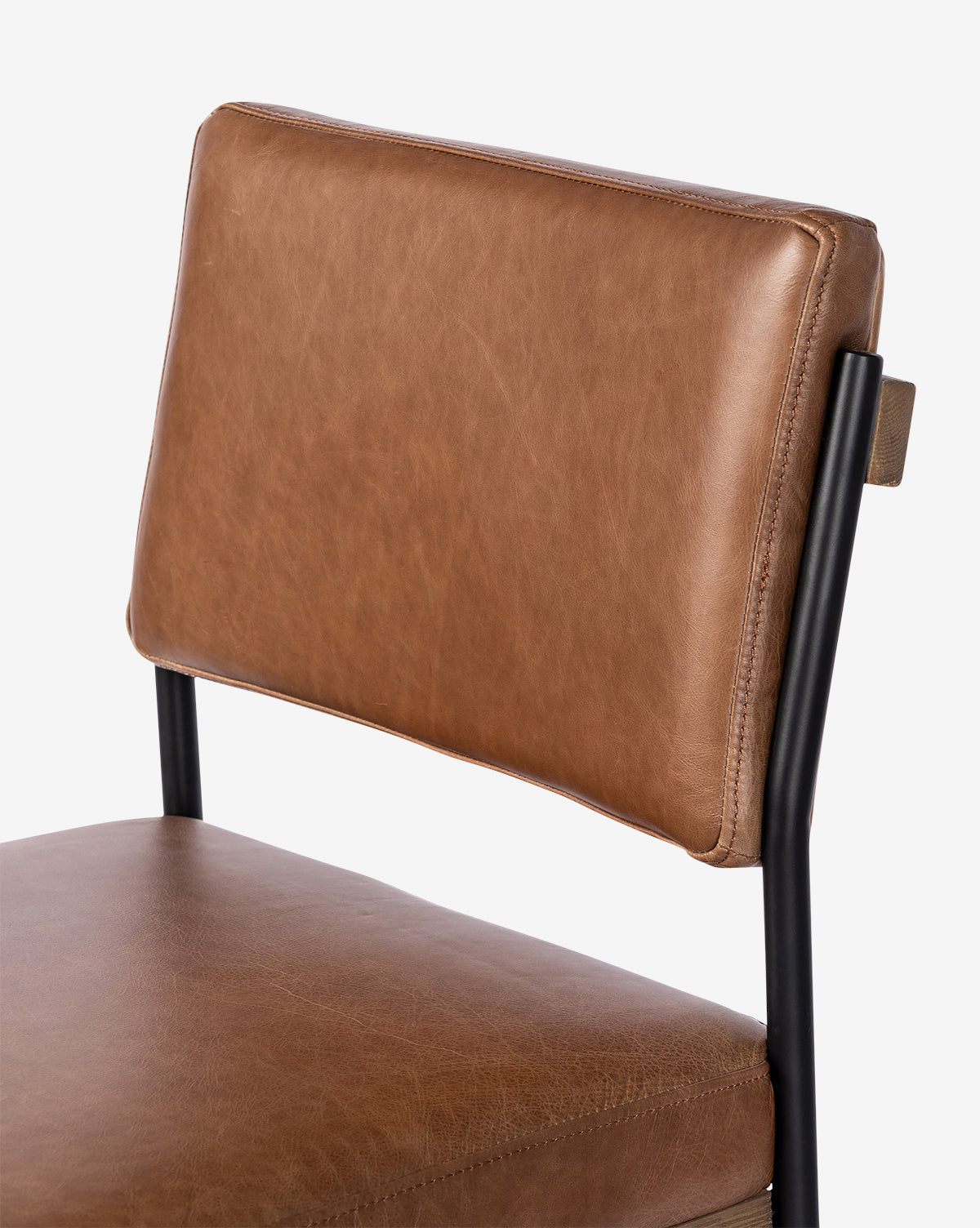 A close-up view of the Pascal Stool highlights its brown leather seat and backrest paired with a black iron frame, set against a plain white background, by Vendixs