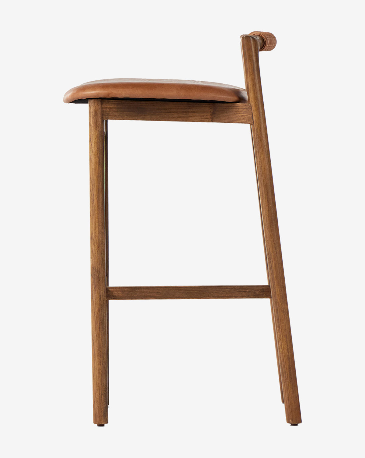 The Patrin Stool by Four Hands showcases an ash wood frame and a brown performance leather-upholstered seat with a low backrest, displayed in profile against a plain white background. Vendixs
