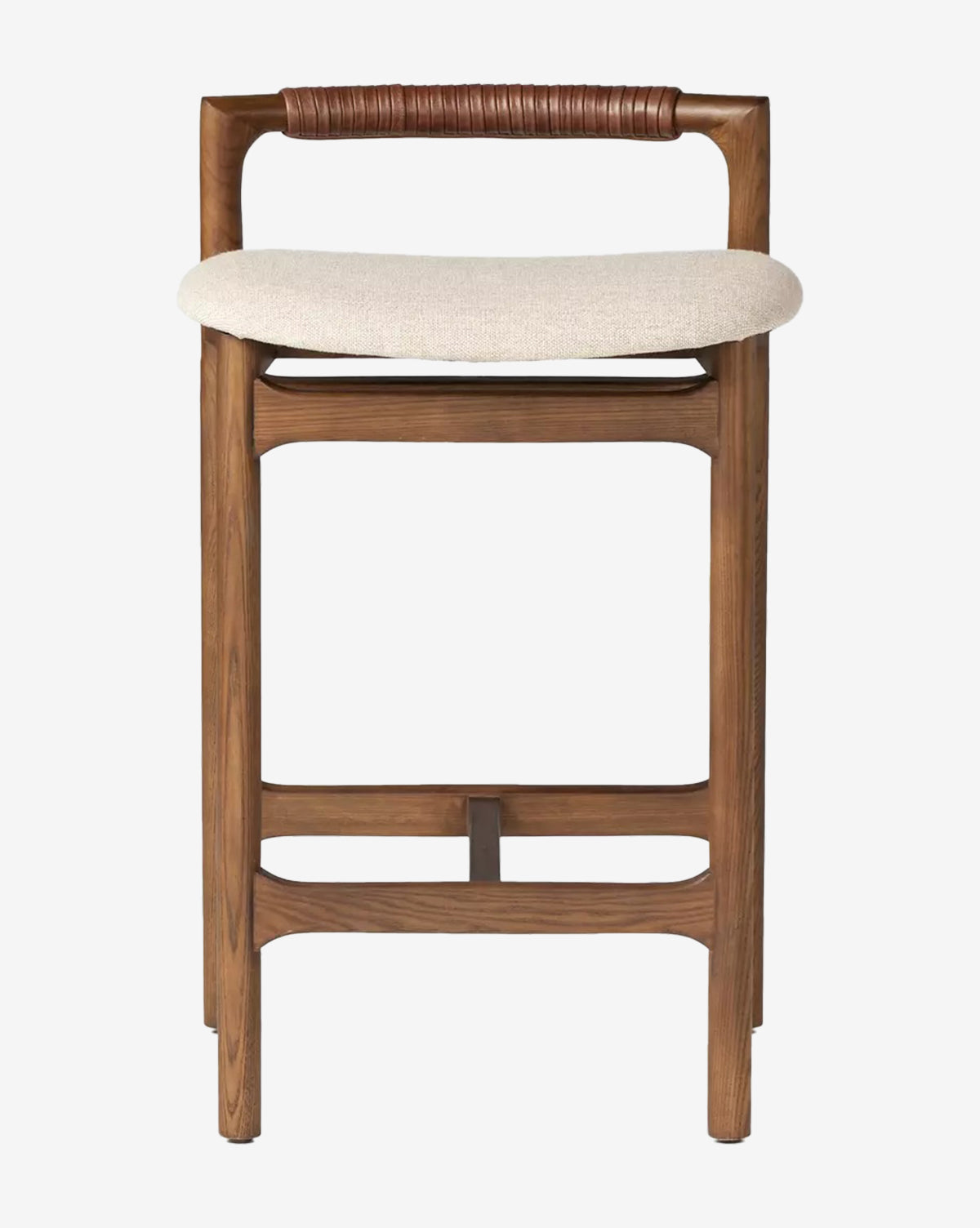 The Four Hands Patrin Stool offers a light beige performance-upholstered seat, a low curved brown leather backrest, and sturdy ash wood legs with horizontal supports, by Vendixs